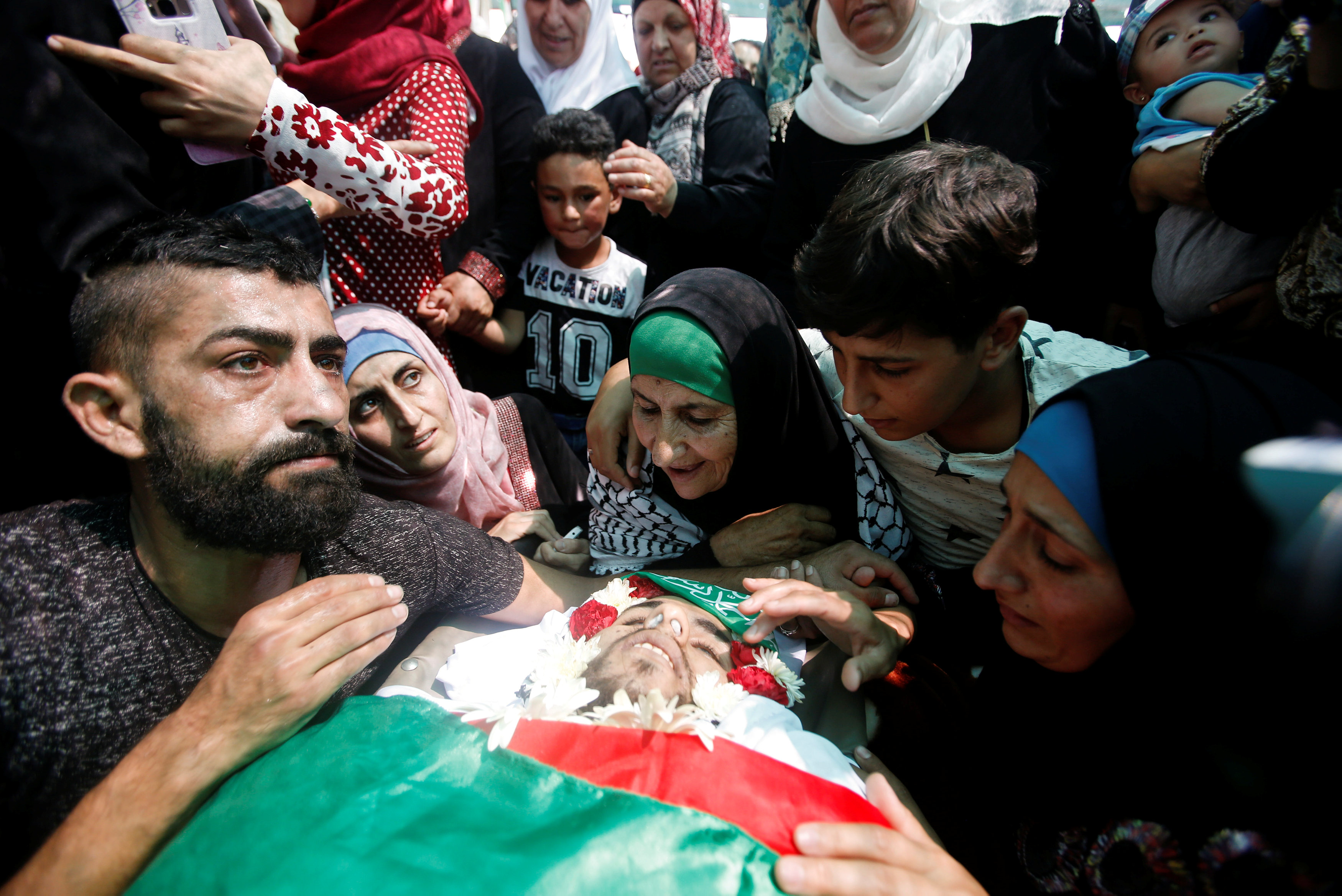 أهل وأصدقاء الشهيد الفلسطينى يلتفون حول جثمانه