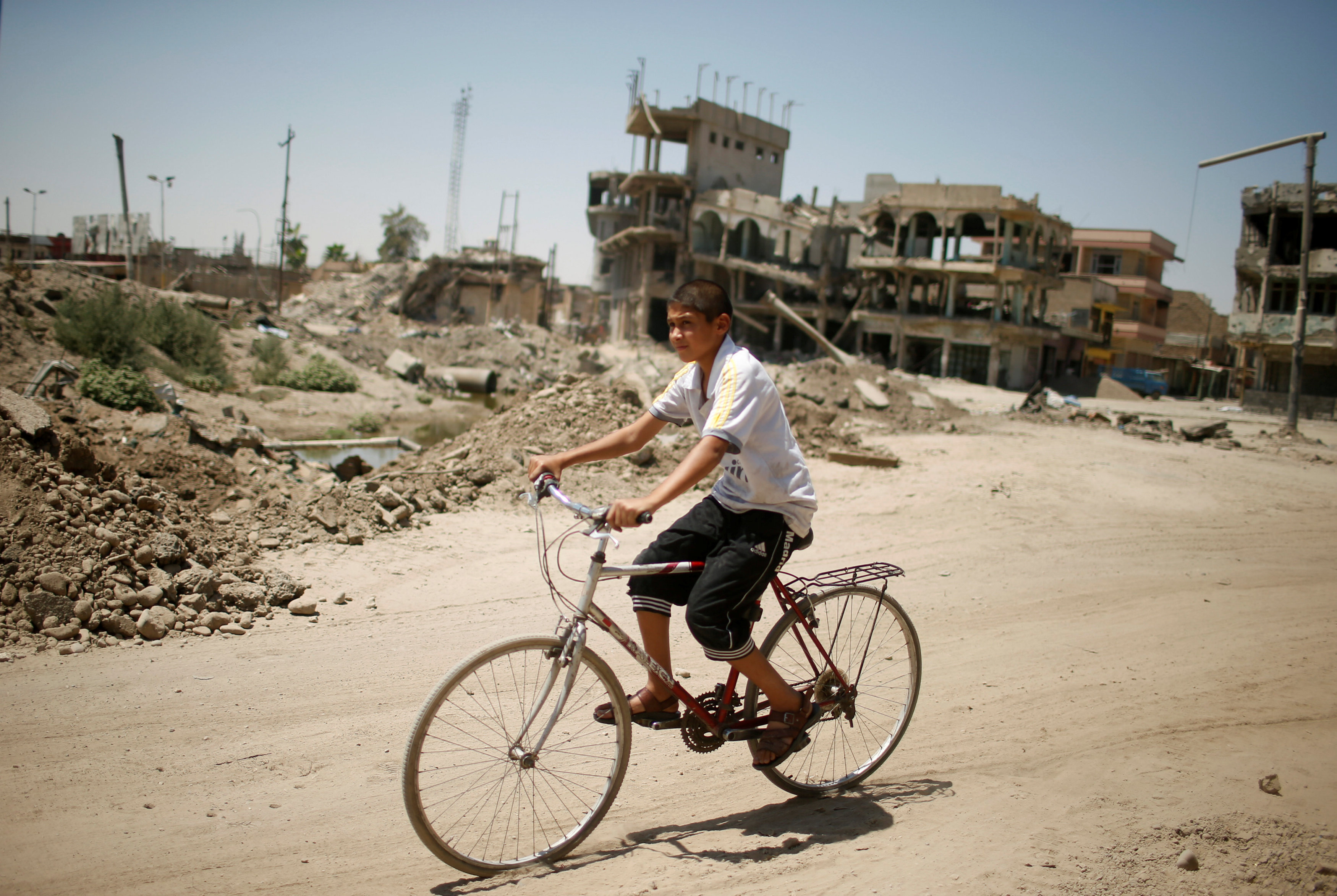 طفل يركب دراجة وسط أطلال مدينة الموصل القديمة