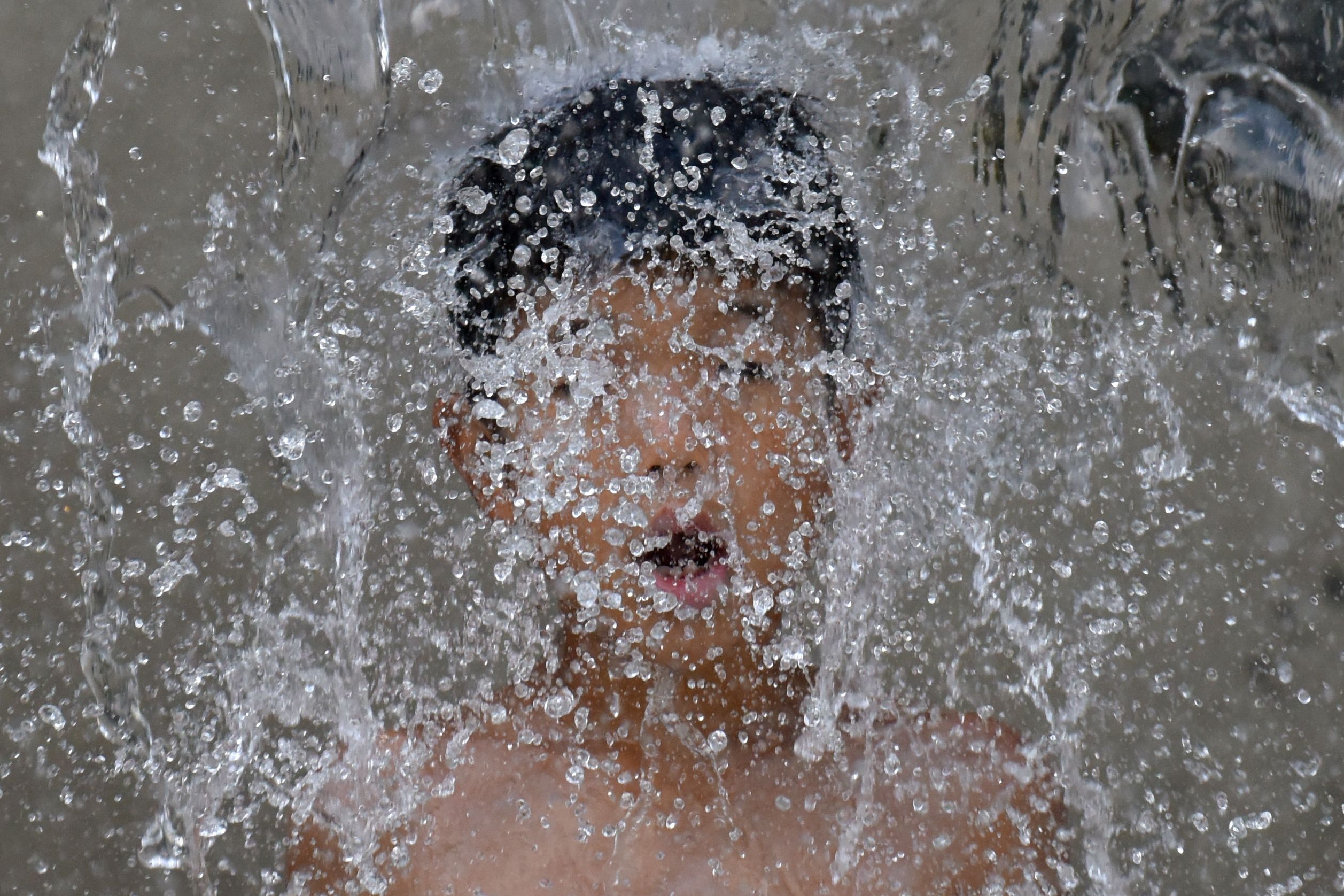 طفل يواجه حرارة الشمس بالاستمتاع بالمياه فى اليابان