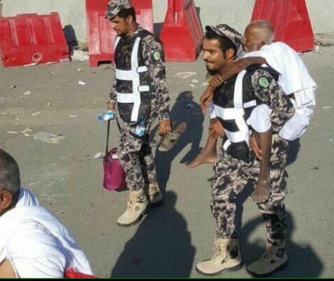جندى سعودى يحمل حاج لمساعدته على أداء المناسك المقدسة