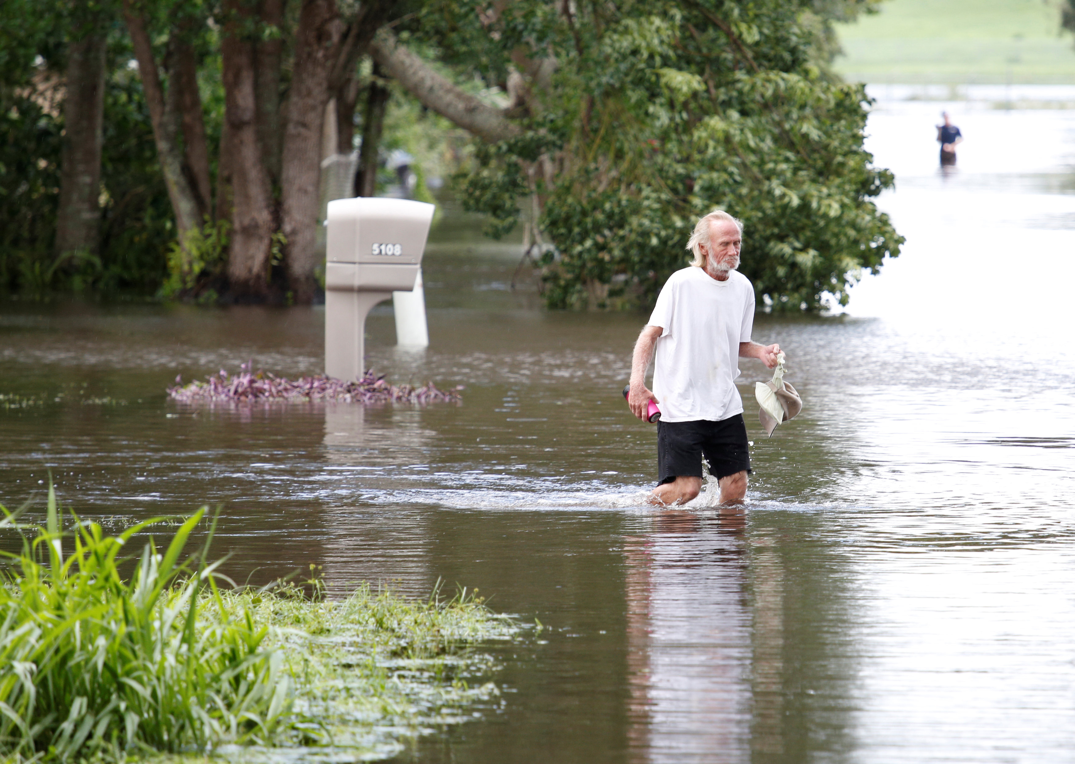 رجل يسير وسط مياه الفيضان