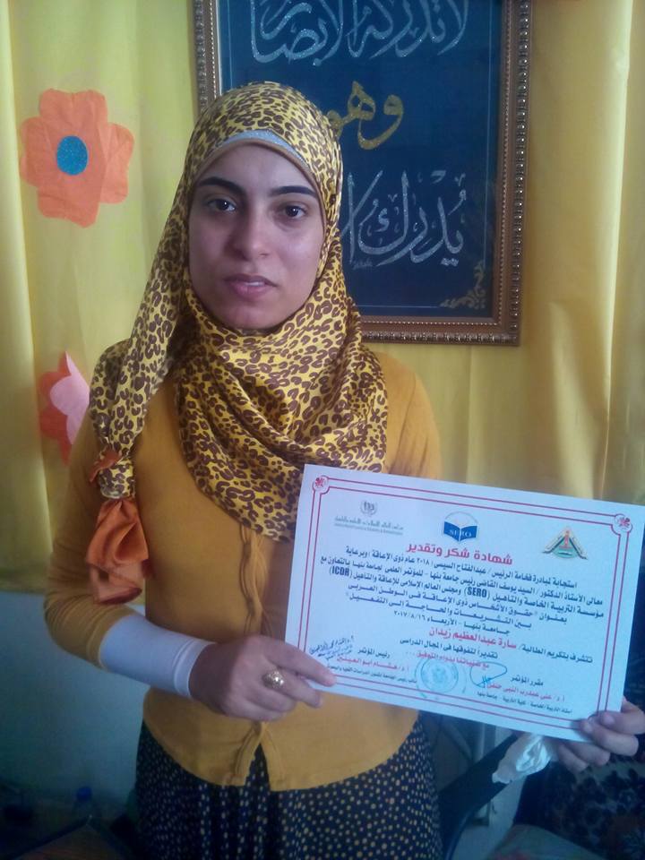 سارة تحمل شهادة تكريم مجلس العالم الإسلامي للمعاقين