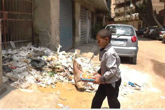 طالب يلقى الكتب المدرسية بجانب القمامة على الارض 