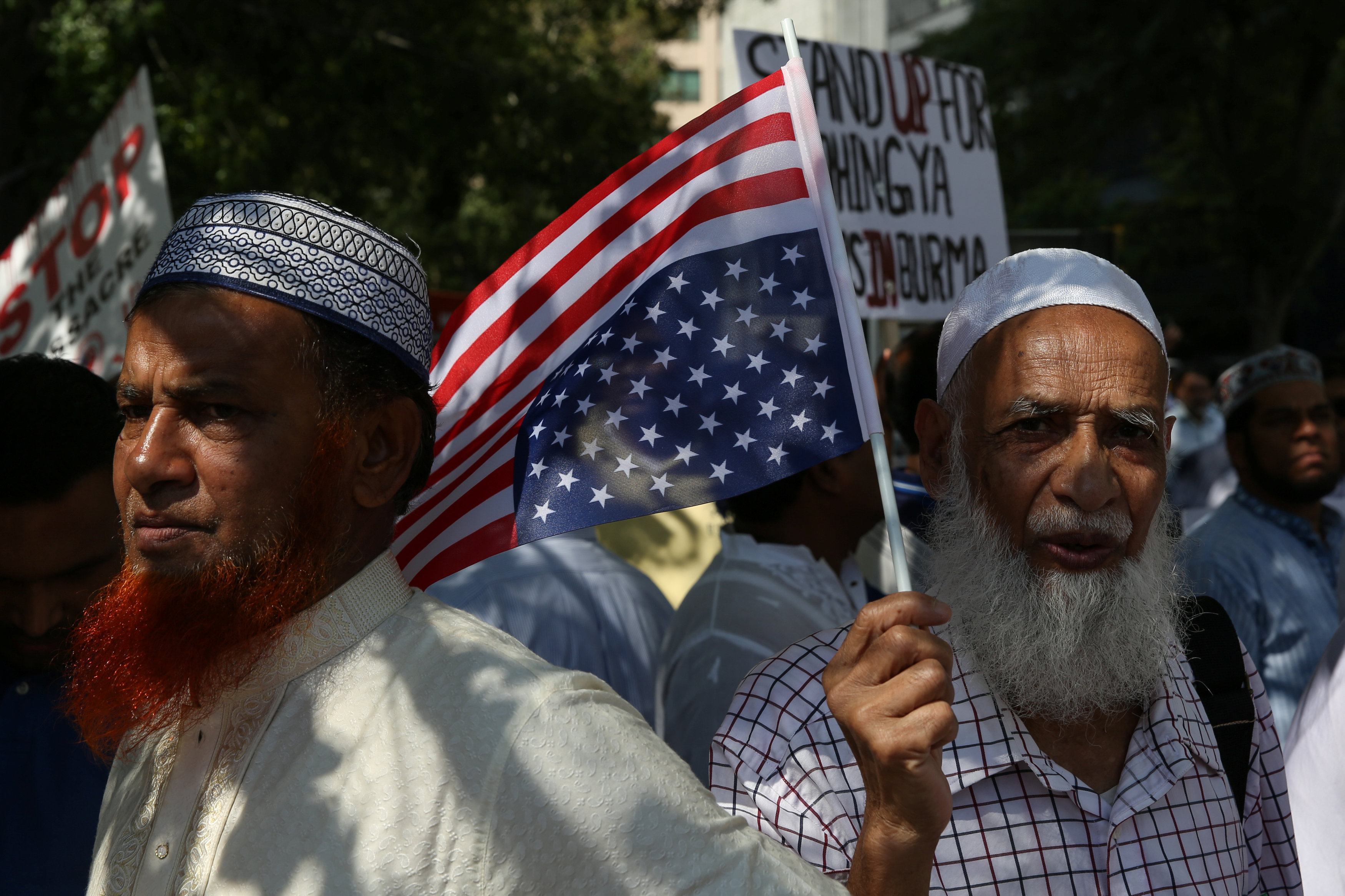 متظاهر يحمل علم أمريكا خلال مظاهرة ضد العنف تجاه الروهينجا