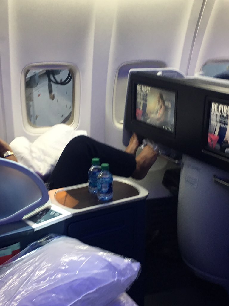 مسافر يضع قدمه أسفر شاشة على متن طائرة