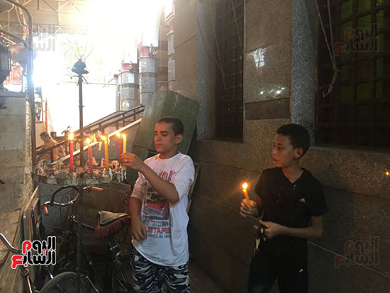 شباب يقومون بإنارة الشموع في ساحة السيوطي