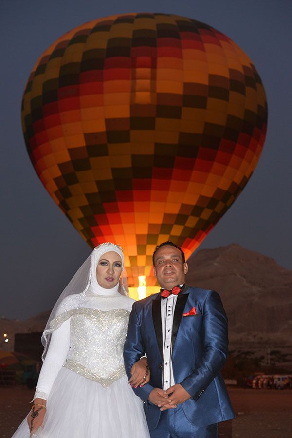 العروسان أمام البالون الطائر قبل الإنطلاق بغرب الاقصر