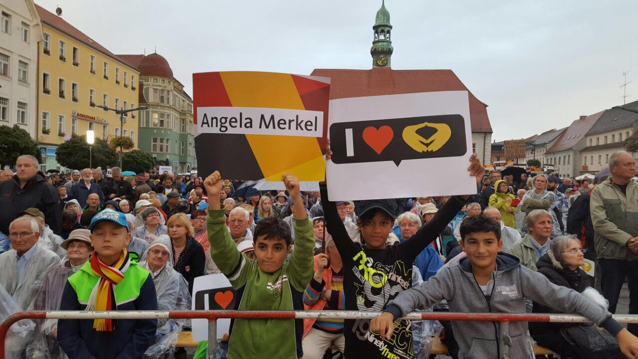 لاجئون يرفعون اسم انجيلا ميركل