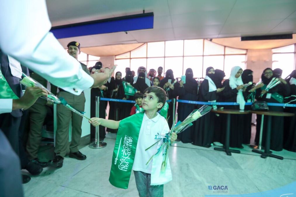 طفل سعودي يوزع الورود على المسافرين بالمطار