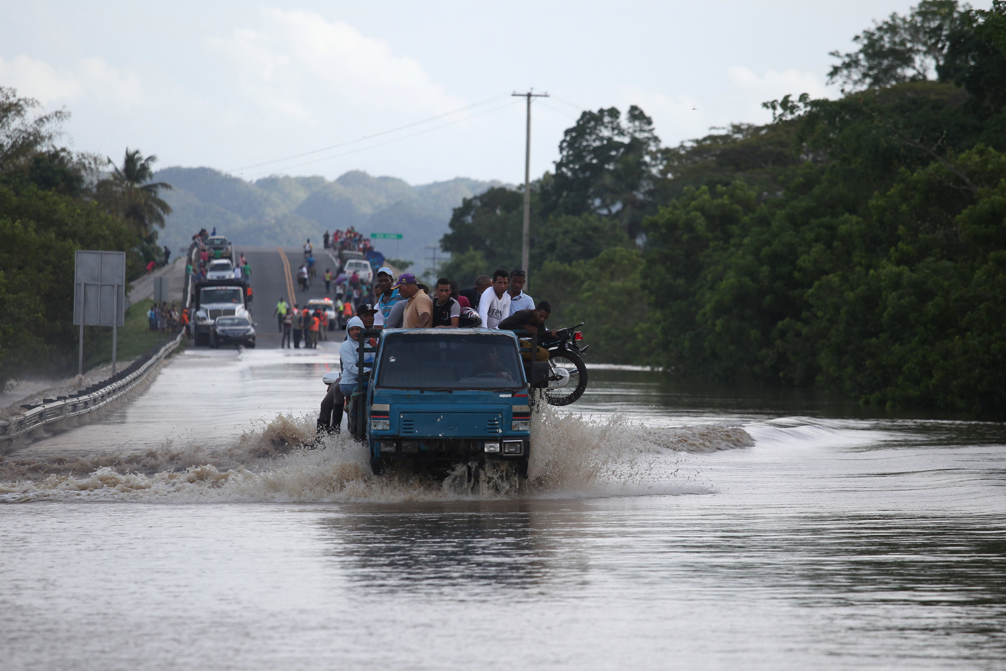 سيارة تقل أشخاصا تعبر بهم بحيرة جمعهتها مياه الامطار
