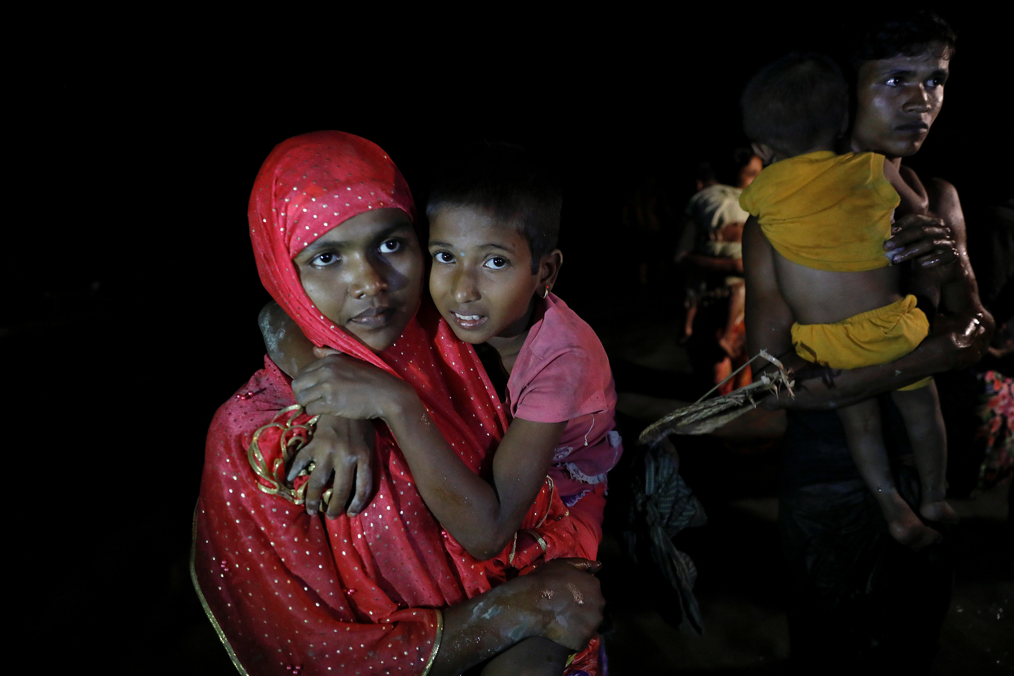 سيدة تحمل ابنها خلال رحلة الهروب من ميانمار