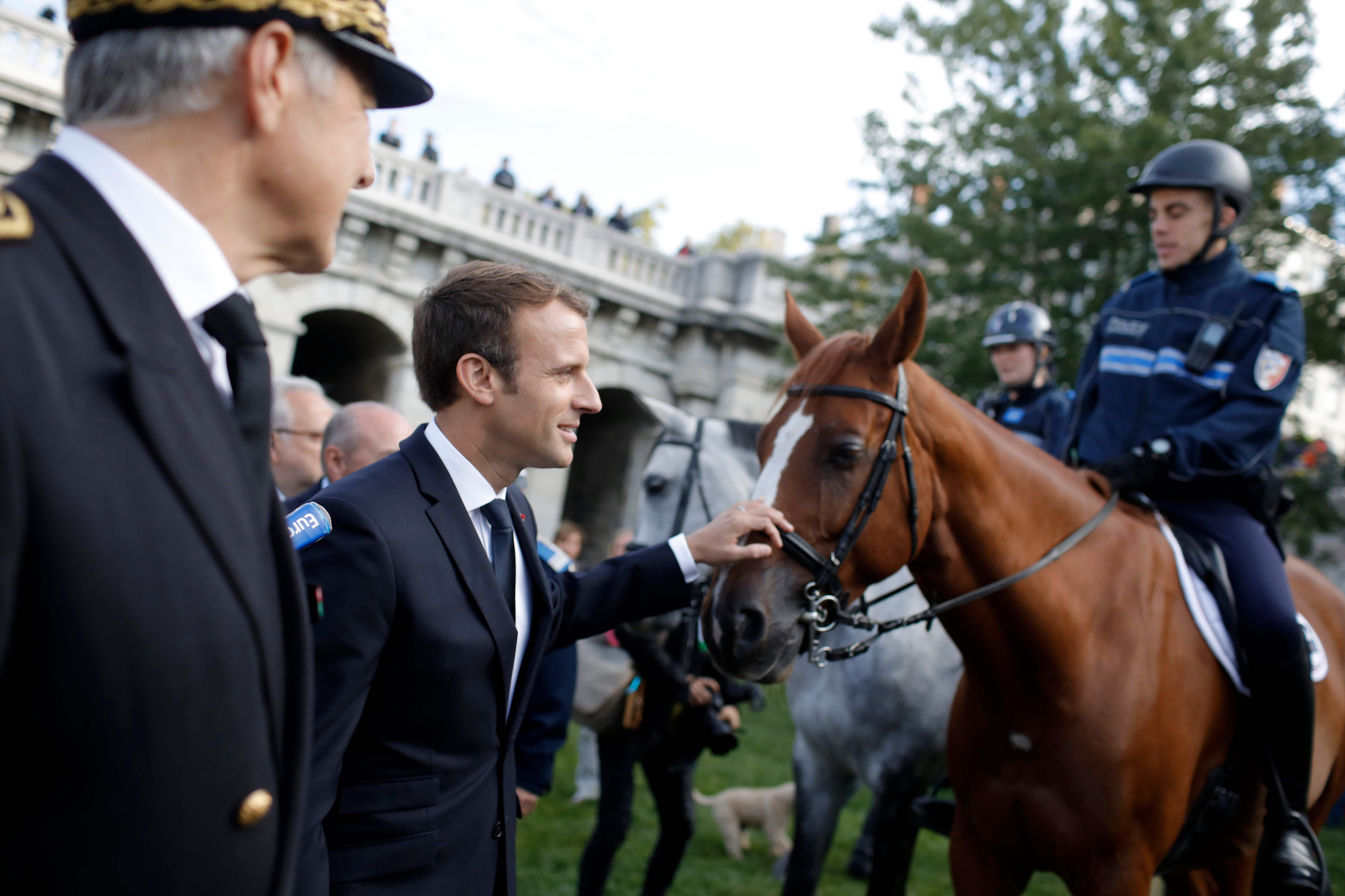 ماكرون يداعب حصان خلال زيارته للشرطة فى مدينة ليون