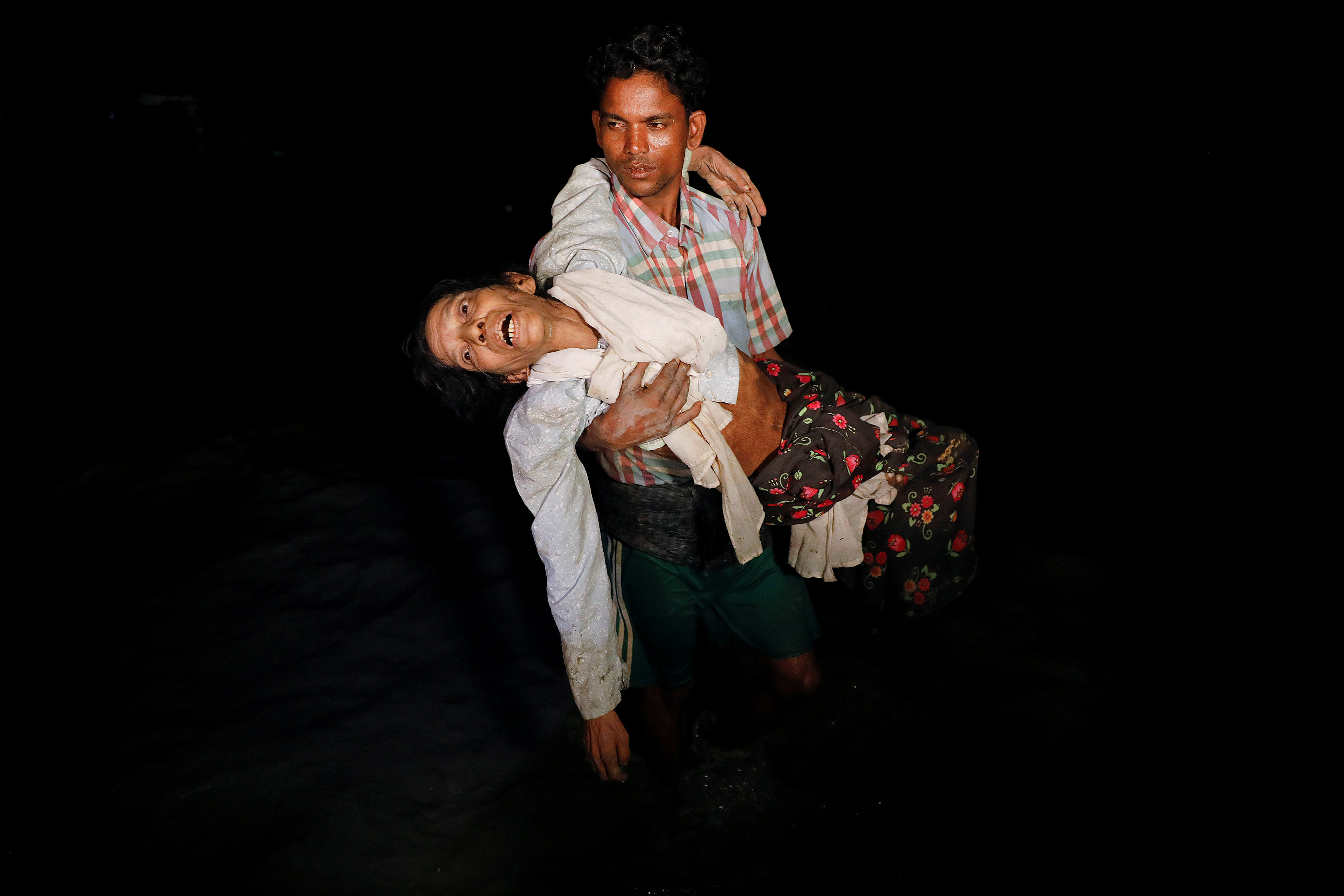 رجل يحمل سيدة خلال الهرب من الاضطهاد فى ميانمار