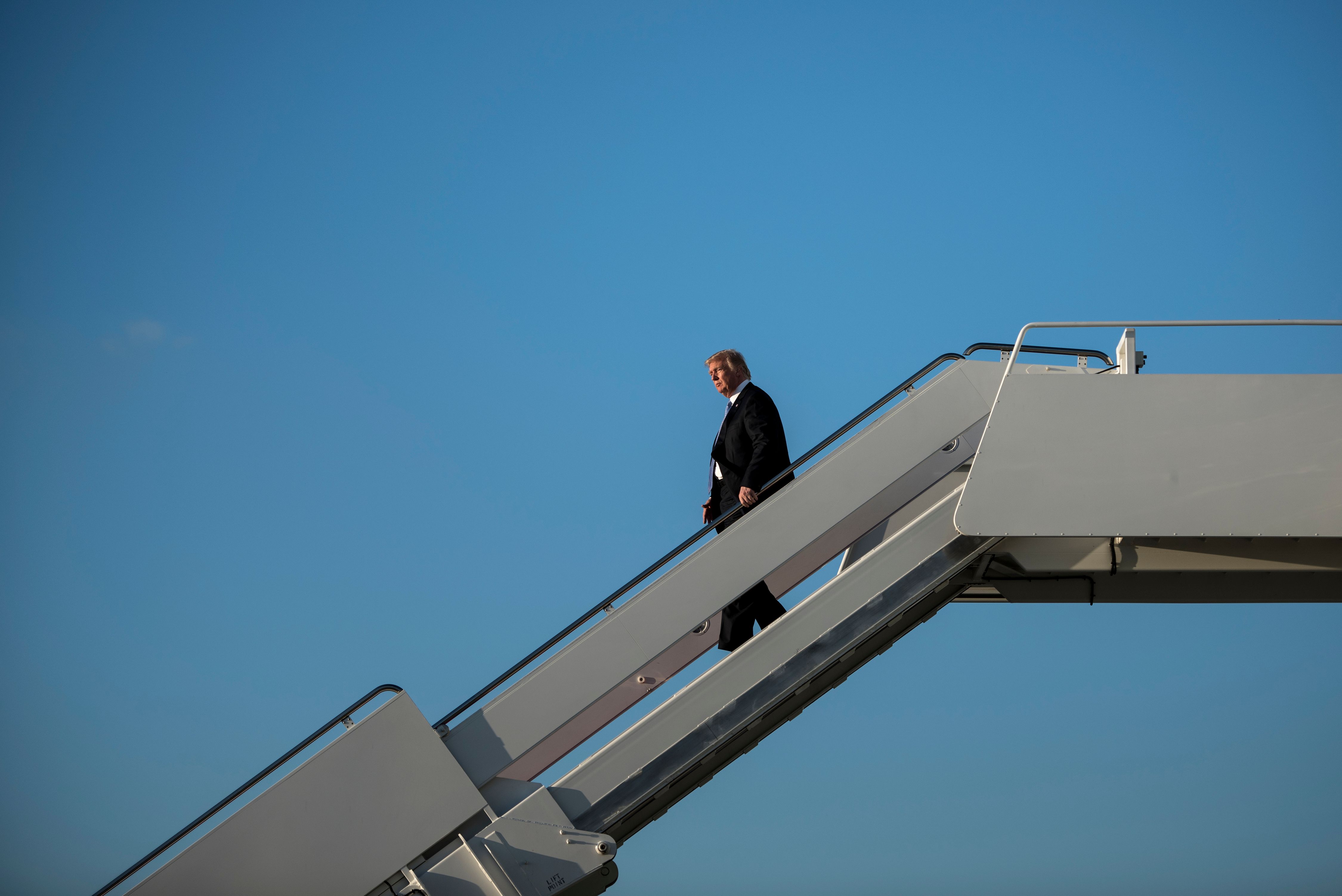 ترامب ينزل على سلم الطائرة فور وصوله واشنطن
