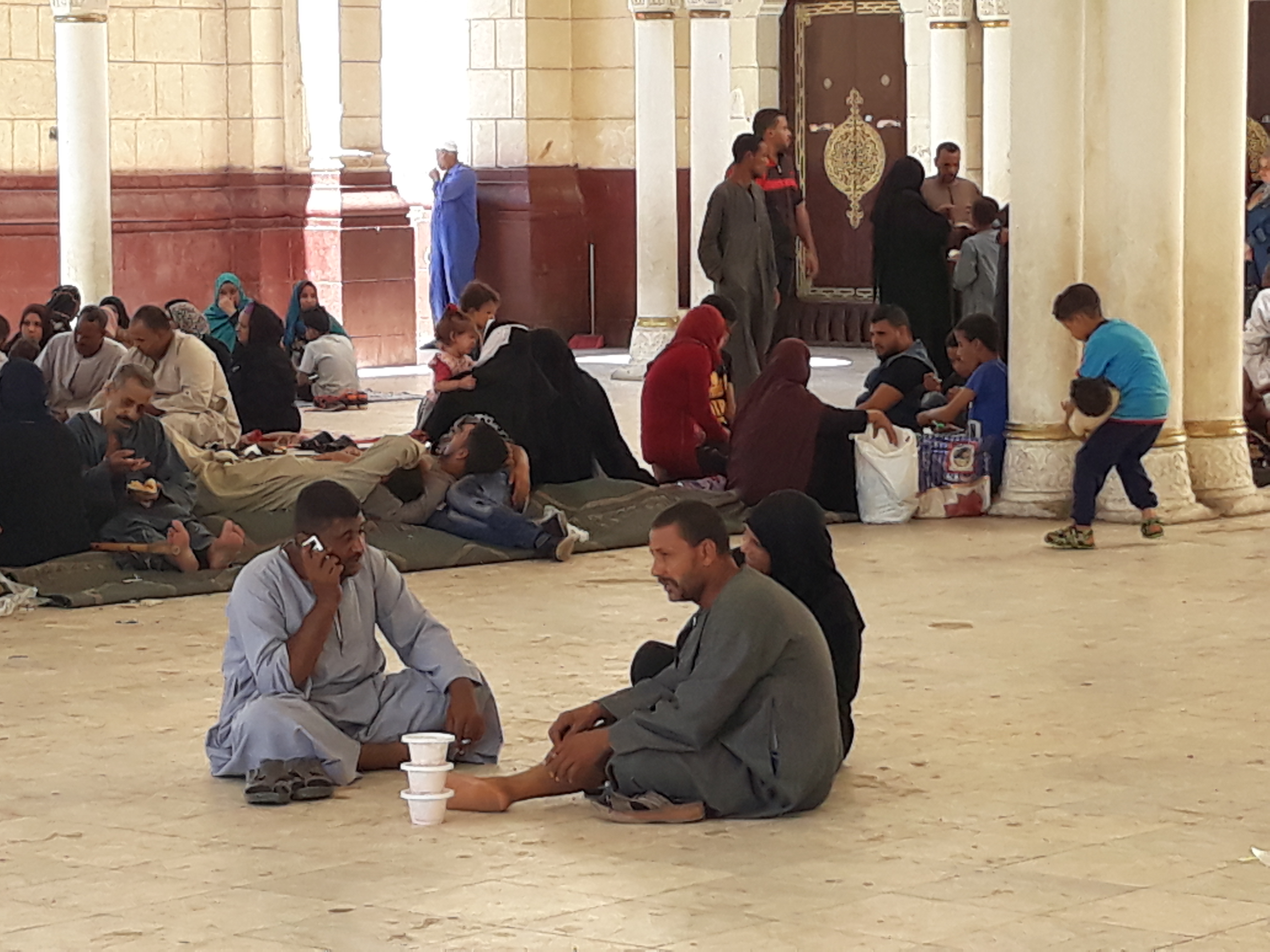 3 أسرة تجلس داخل صحن المسجد بعد تناول وبجة الغذاء