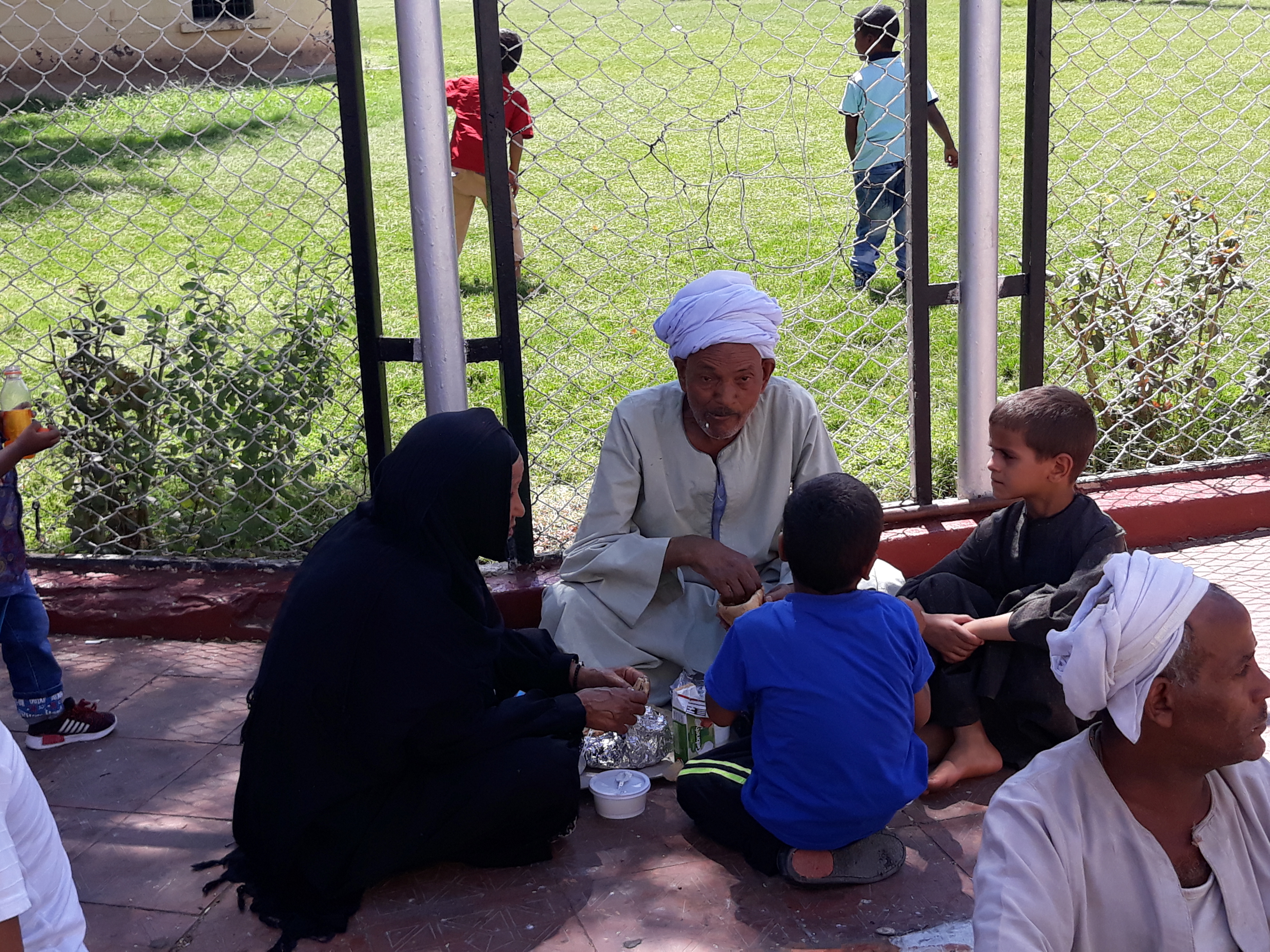 2 رجل مسن يتناول الغذاء بصحبة أحفادة بمسجد القنائى