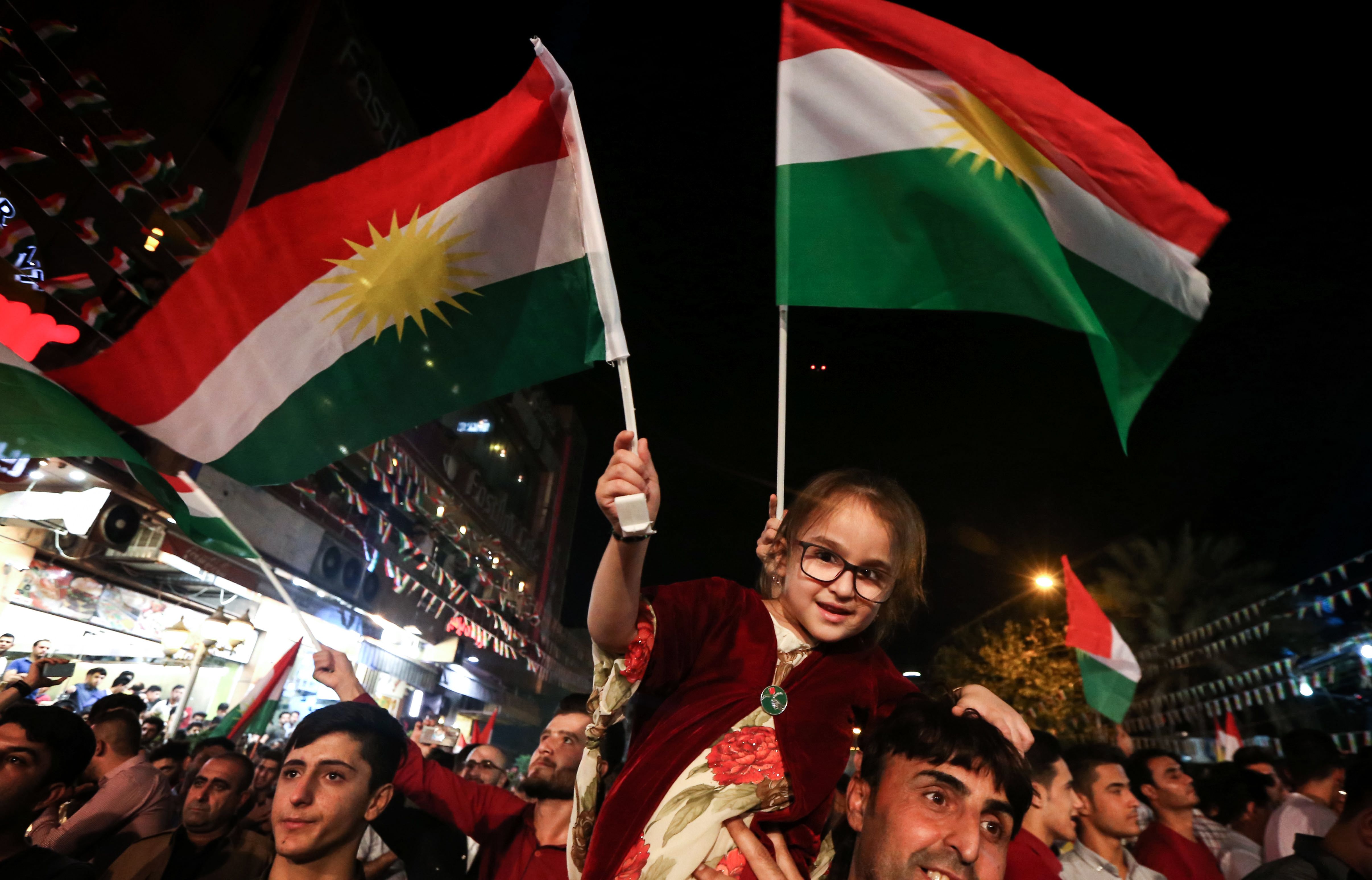 رجل يحمل طفلته خلال احتفالات استفتاء استقلال كردستان العراق