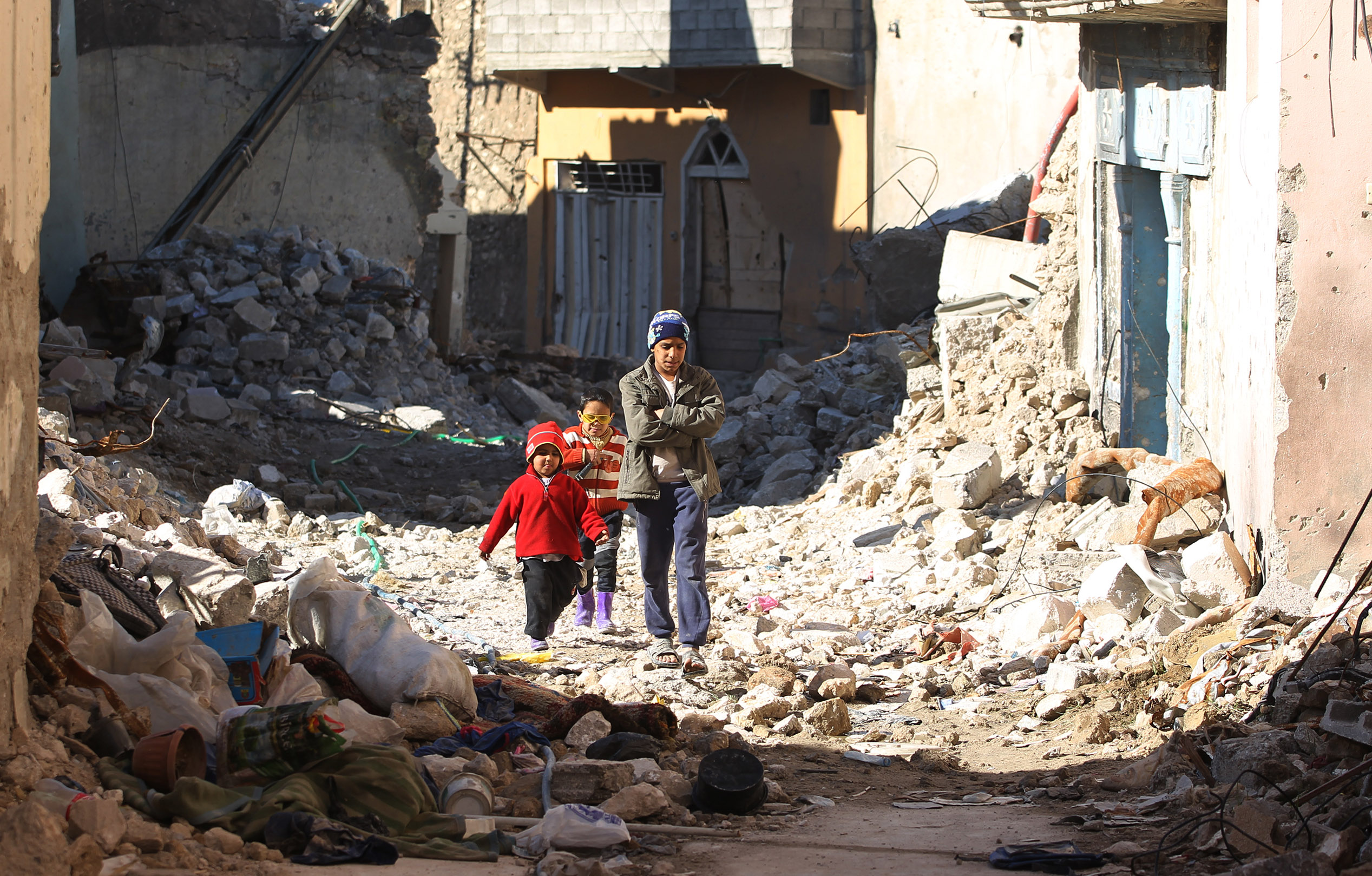 أطفال يسيرون وسط المبانى المدمرة فى مدينة الموصل