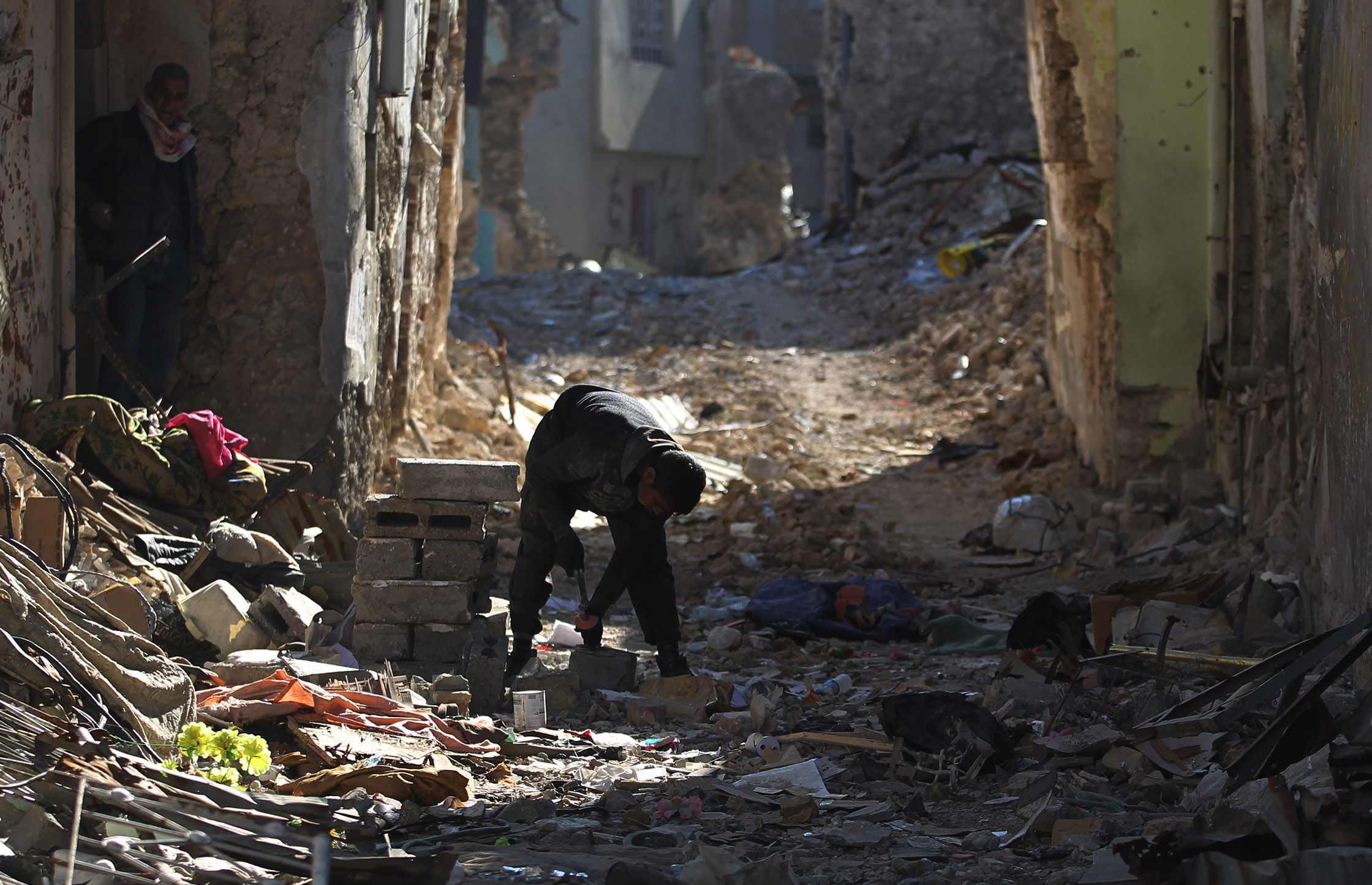 شاب عراقى يقف وسط حطام المبانى المدمرة إثر الحرب