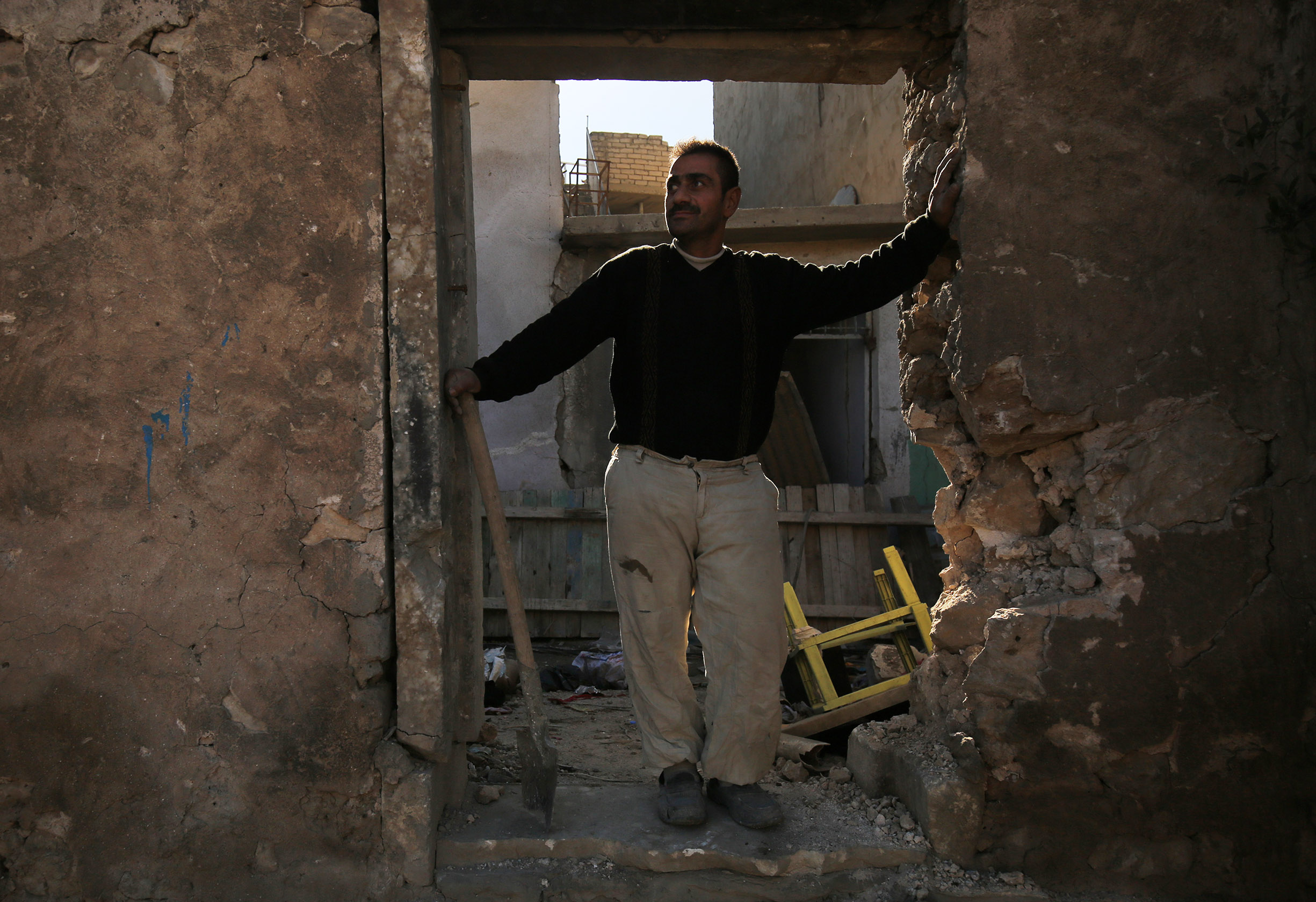 مواطن عراقى يقف أمام منزله المنهار فى الموصل