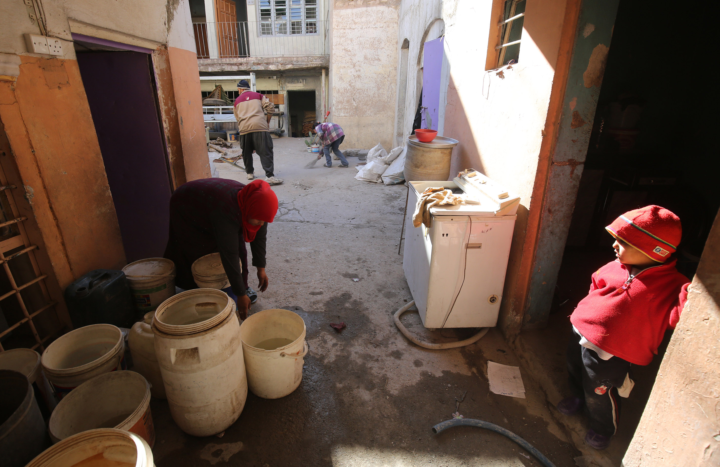 أسرة عراقية تنظف وترمم منزلها المنهار إثر الحرب