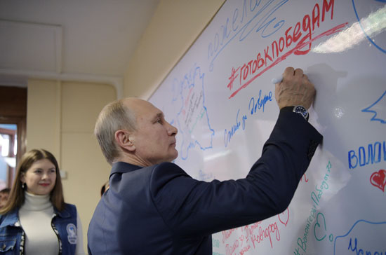 بوتين يوقع داخل مقر الحملة