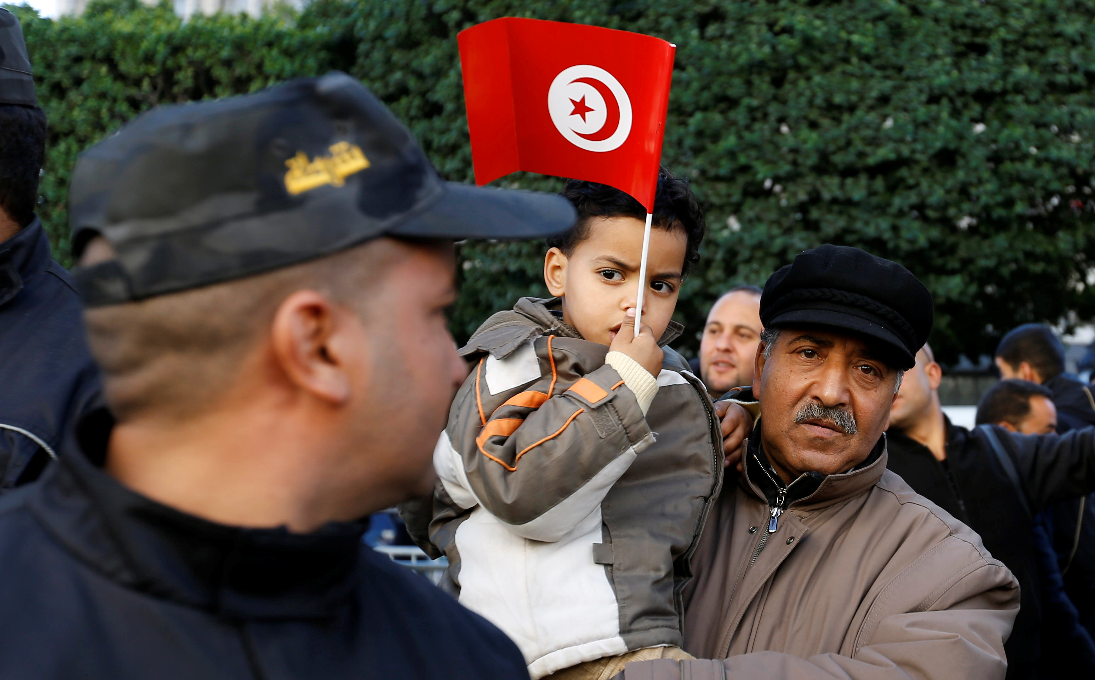 مواطن تونسى يحمل ابنه خلال احتفالات ذكرى الثورة