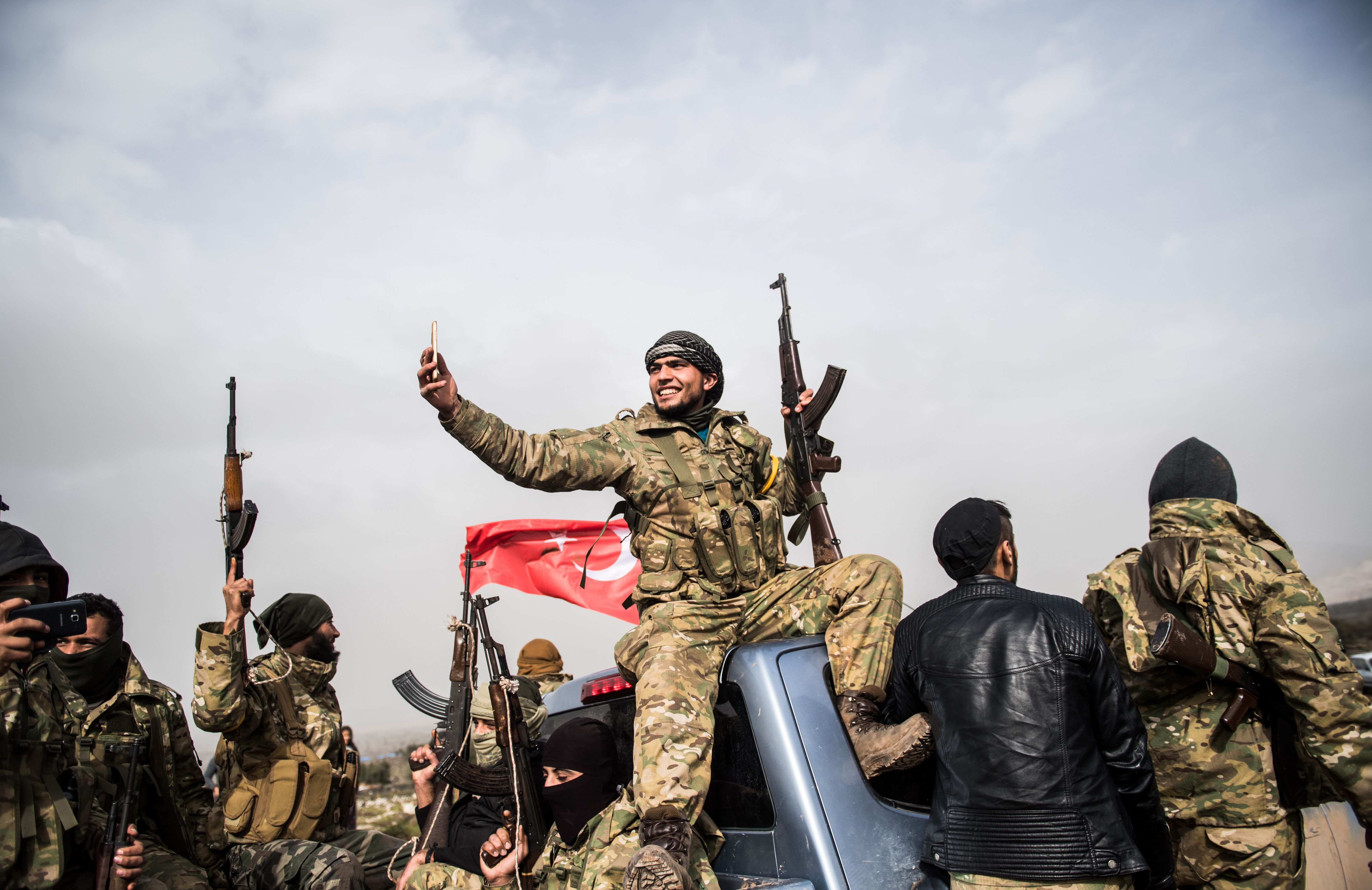 أحد مسلحى المعارضة يلتقط سيلفى مع الآليات التركية