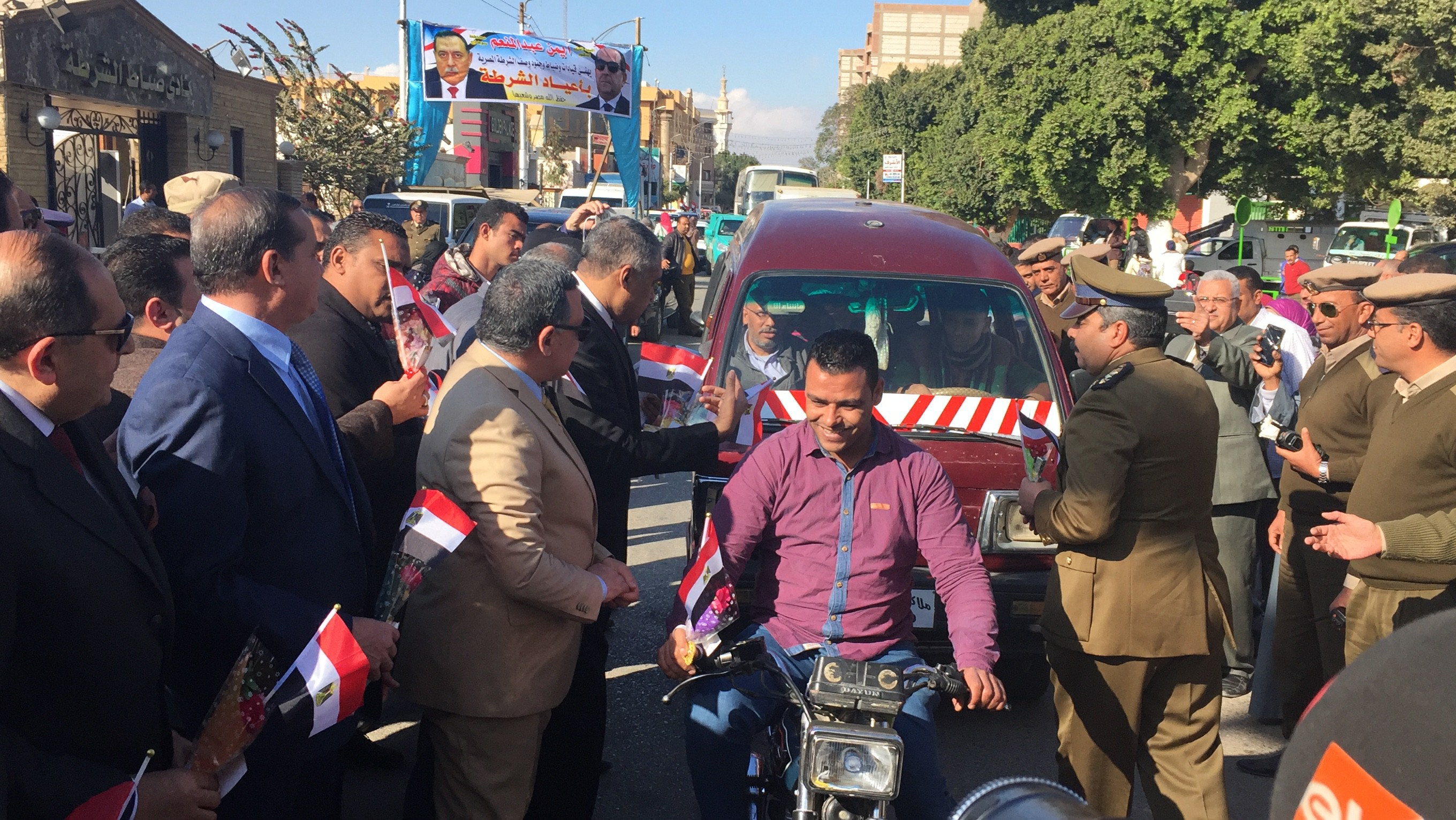  محافظ سوهاج يسلم قائد دراجة بخارية يسلم ورود بعيد الشرطة