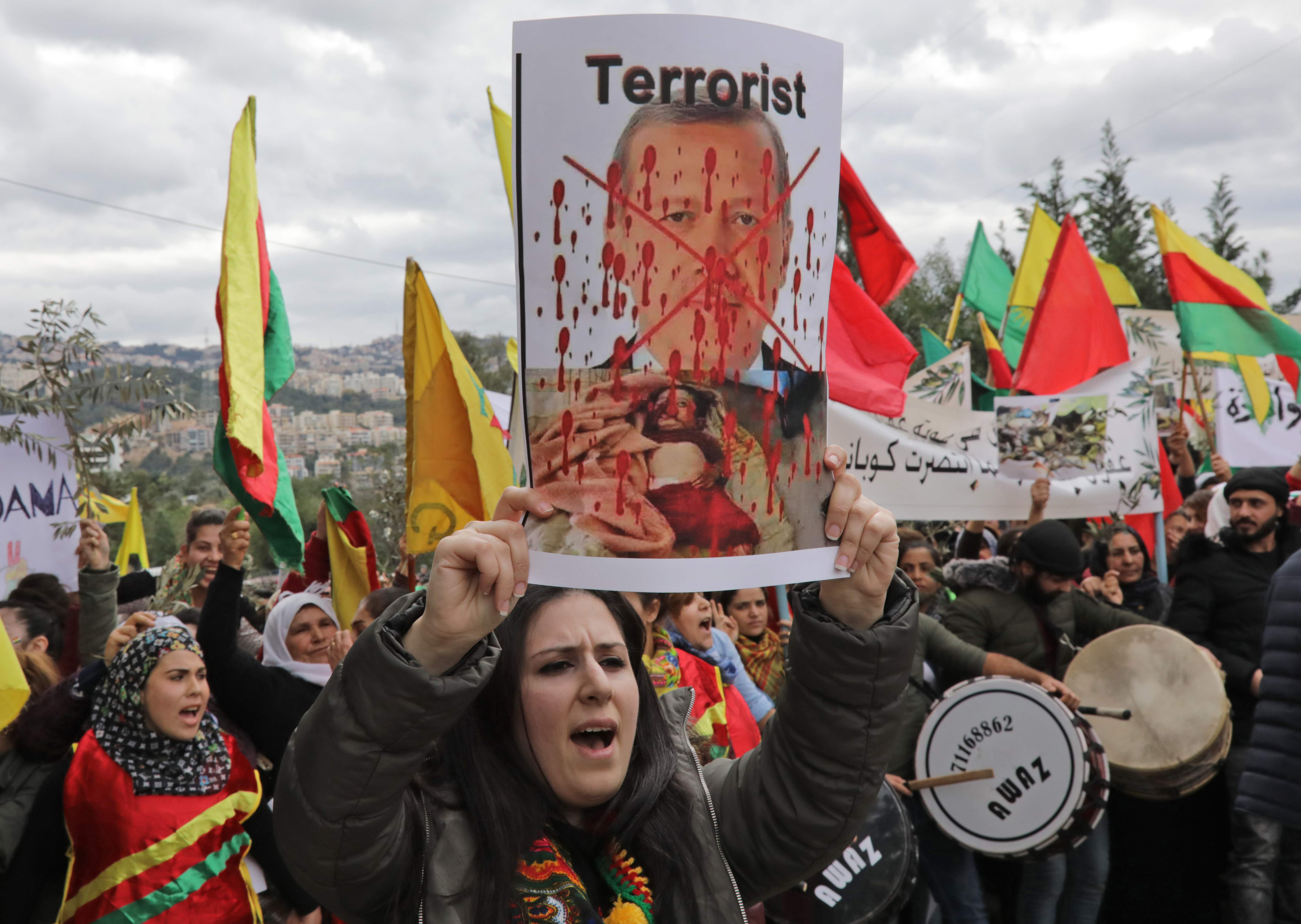 أحد المتظاهرات تحمل صورة أردوغان بشعار الإرهابى