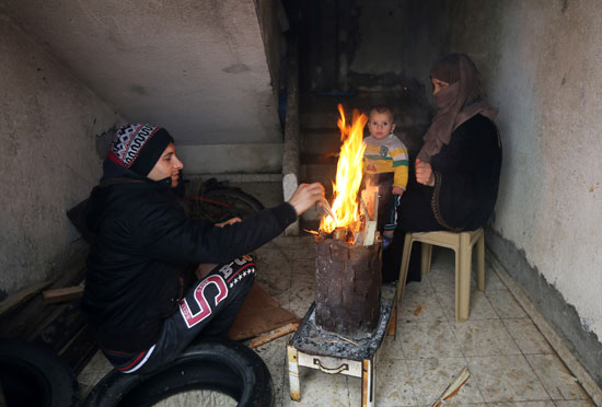 فلسطينيون يتدفئون على الحطب بسبب برودة الطقس