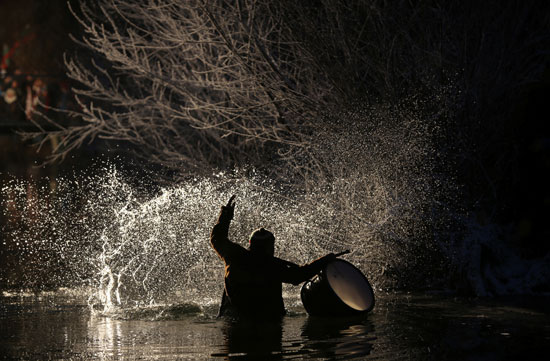 رجل ينثر مياه النهر احتفالا بعيد الغطاس فى بلغاريا