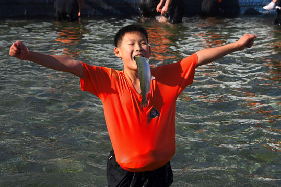 شاب يحتفل باصطياده سمكة خلال المهرجان