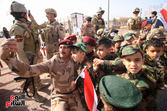 صور تذكارية للقوات العراقية مع الأطفال فى ذكرى تأسيس الجيش