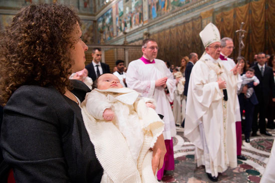 أم تحمل طفلها لتعميده على يد بابا الفاتيكان