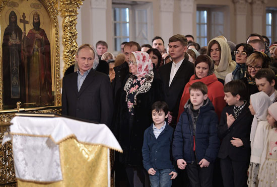 الرئيس بوتين ينظر إلى الأطفال خلال قداس عيد الميلاد