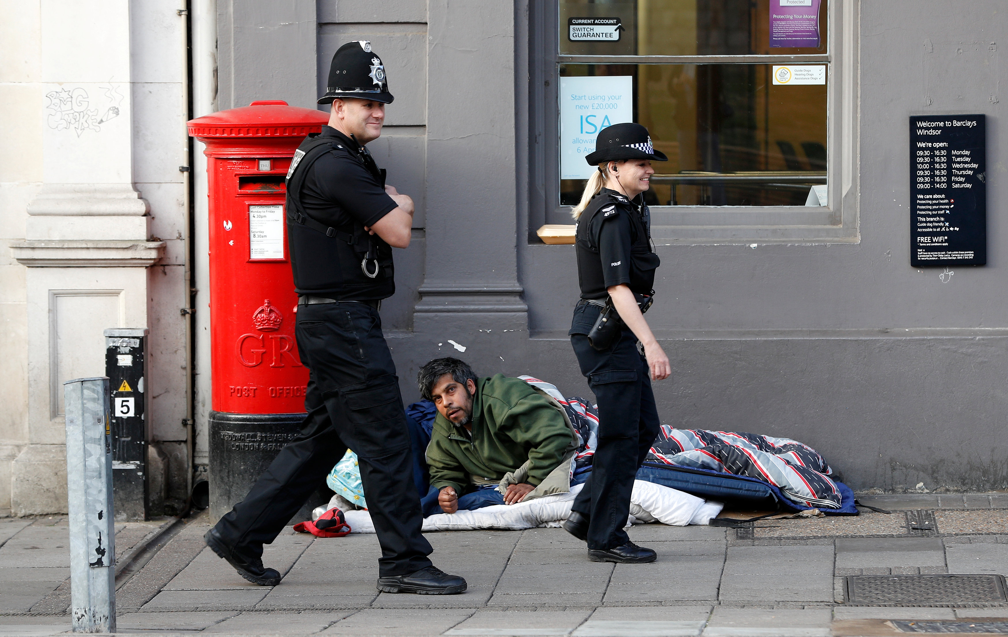 الشرطة البريطانية تمر بجوار أحد المشردين