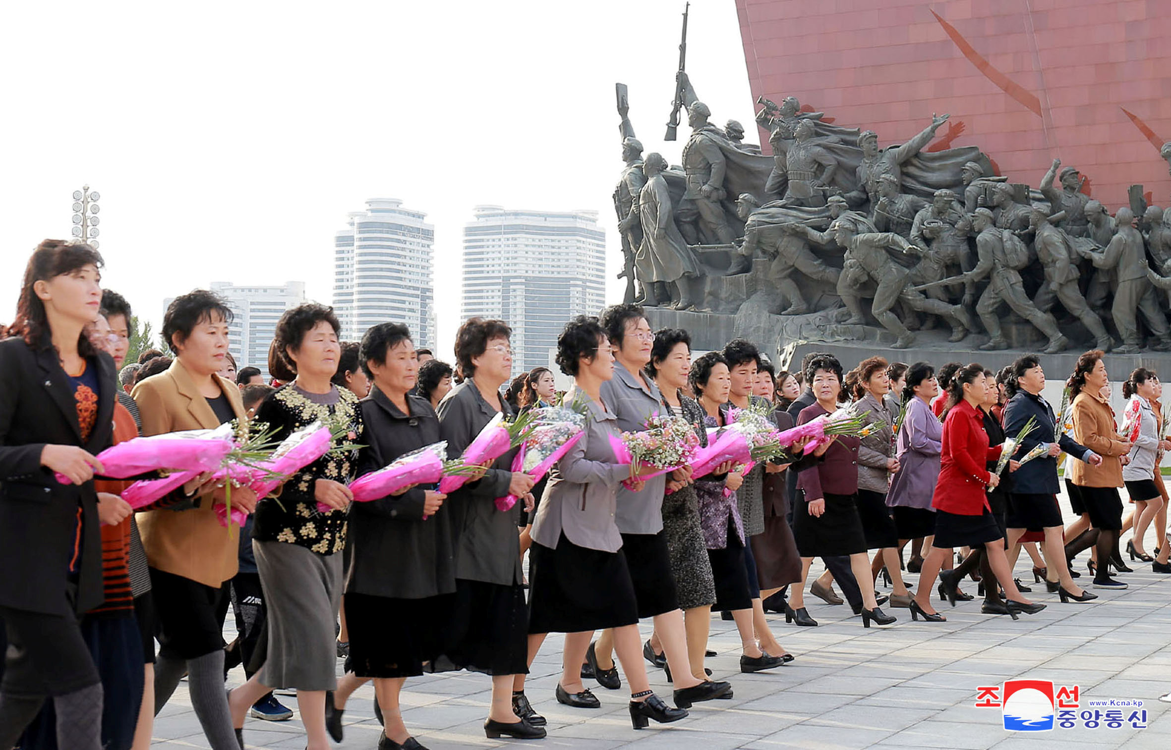 مواطنات كوريا الشمالية يحملون الورود أمام النصب التذكارى لمؤسس كوريا الشمالية