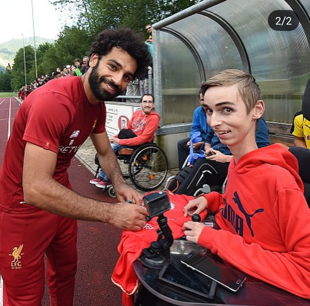 محمد صلاح يبتسم مع أحد مشجعيه من ذوى الإحتياجات الخاصة