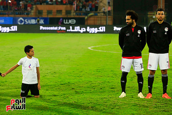 محمد صلاح ينظر إلى أحد معجبيه من الأطفال المصاحبين للاعبين أثناء النزل إلى أرض الملعب