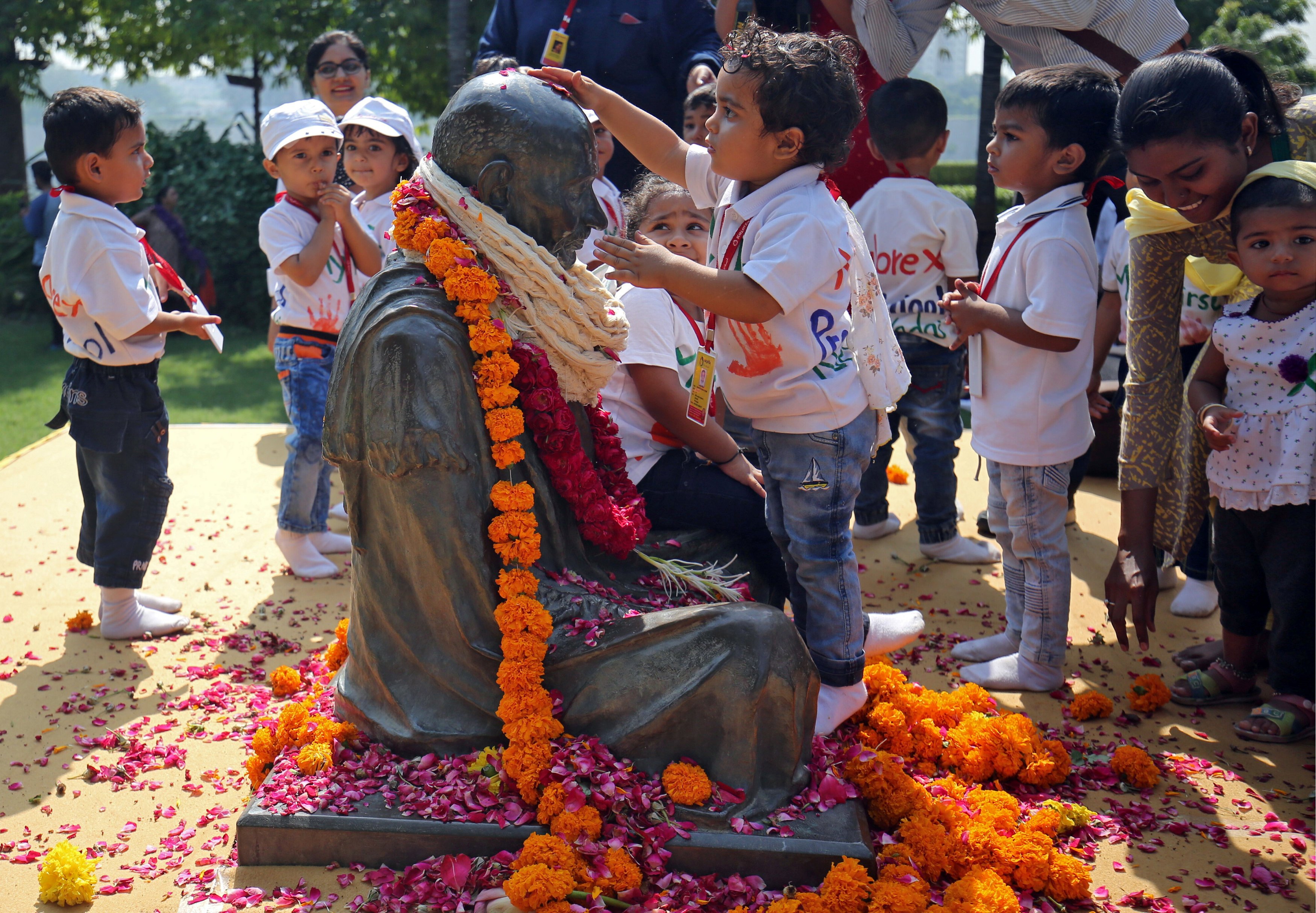 طفل يضع الزهور على تمثال مهاتما غاندى