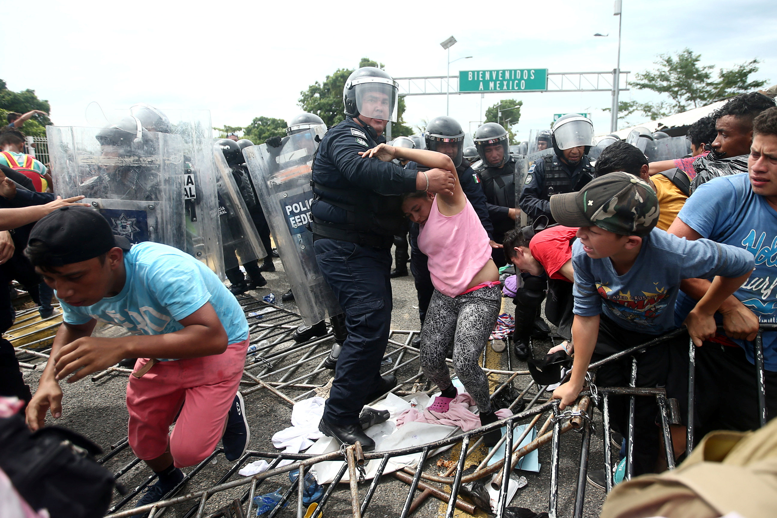أحد عناصر الشرطة يحاول منع سيدة من العبور إلى جواتيمالا