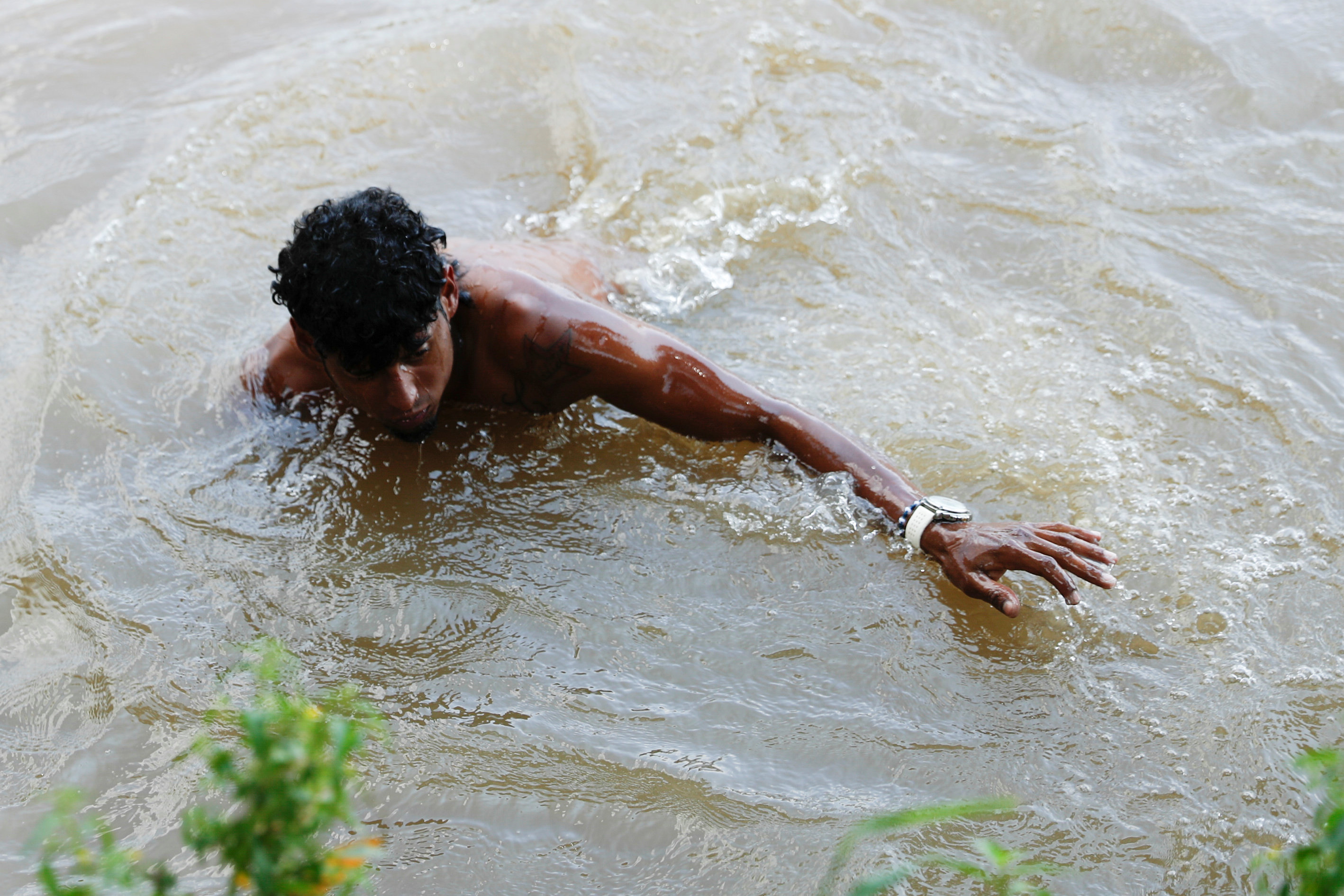 مهاجر هندوراسى يسبح فى المياه