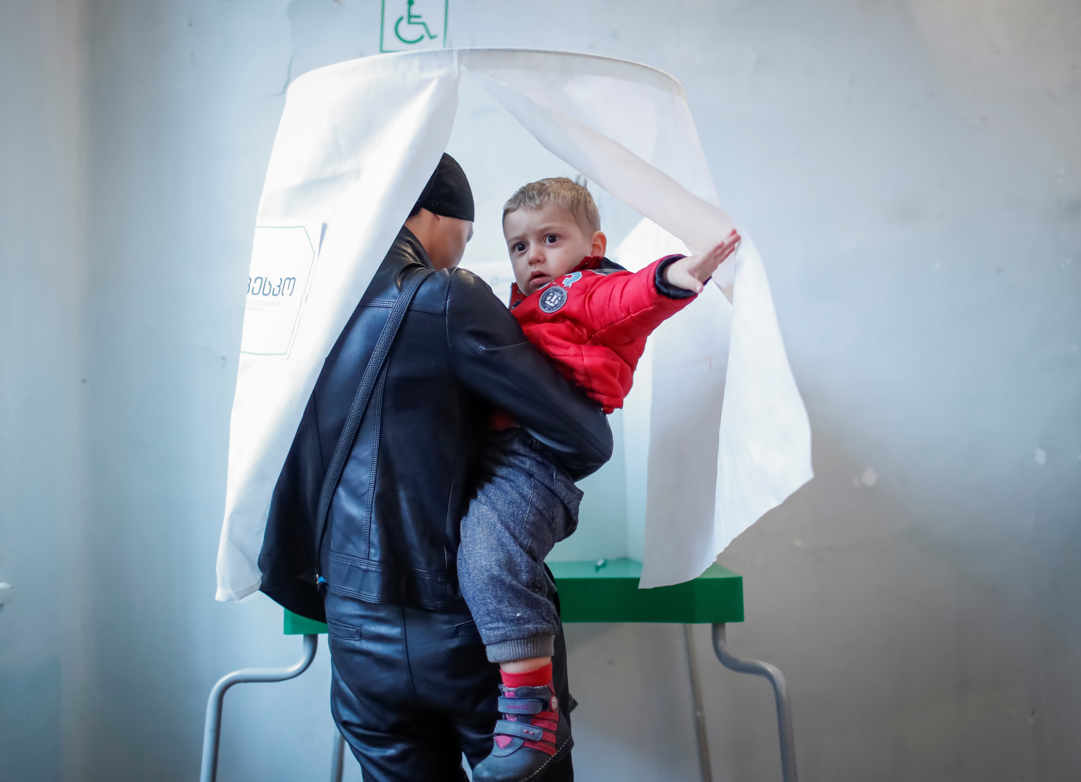 مواطن يصحب طفله أثناء التصويت فى انتخابات الرئاسة بجورجيا