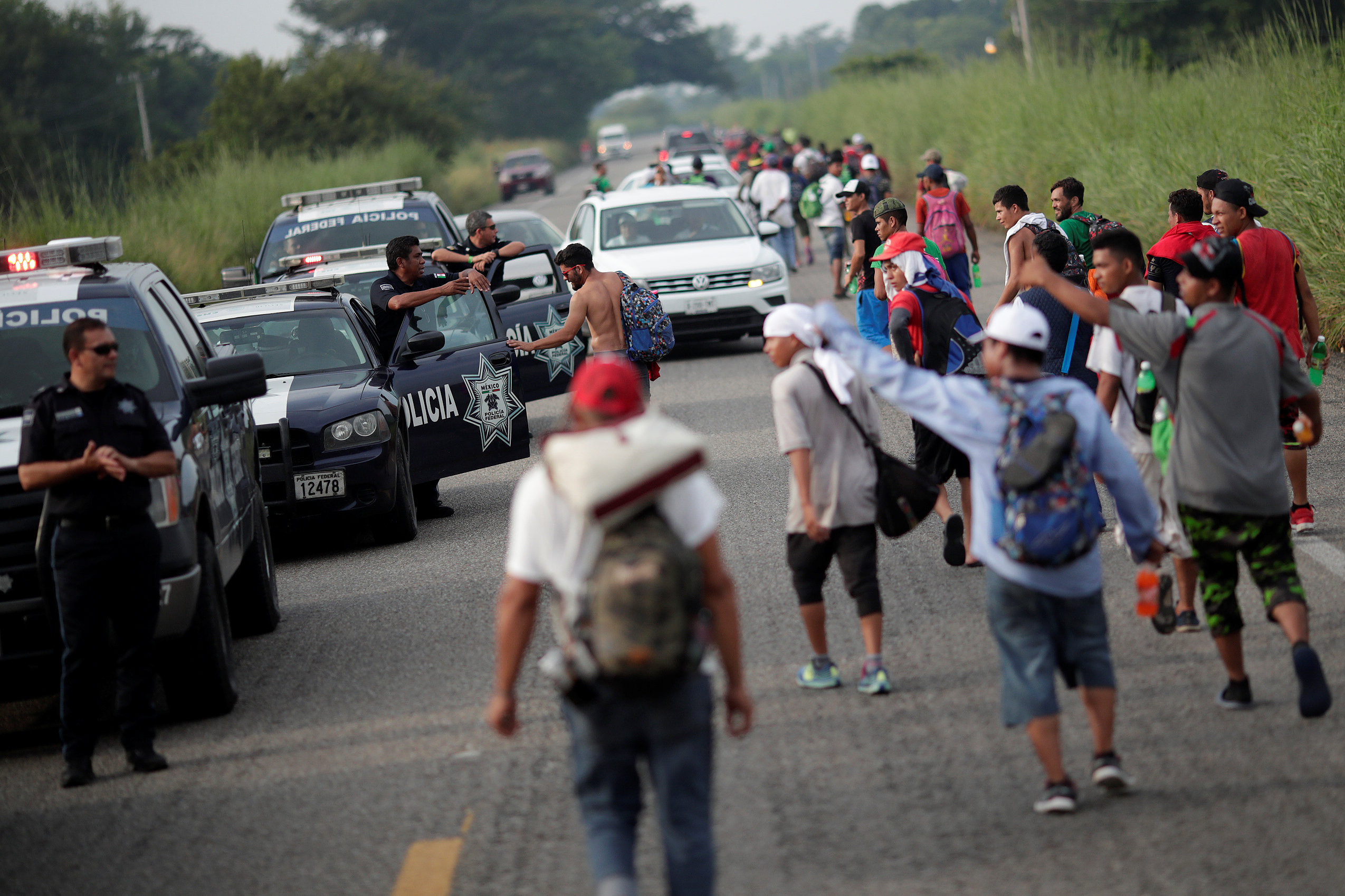 المهاجرون يسيرون أمام الشرطة المكسيكية