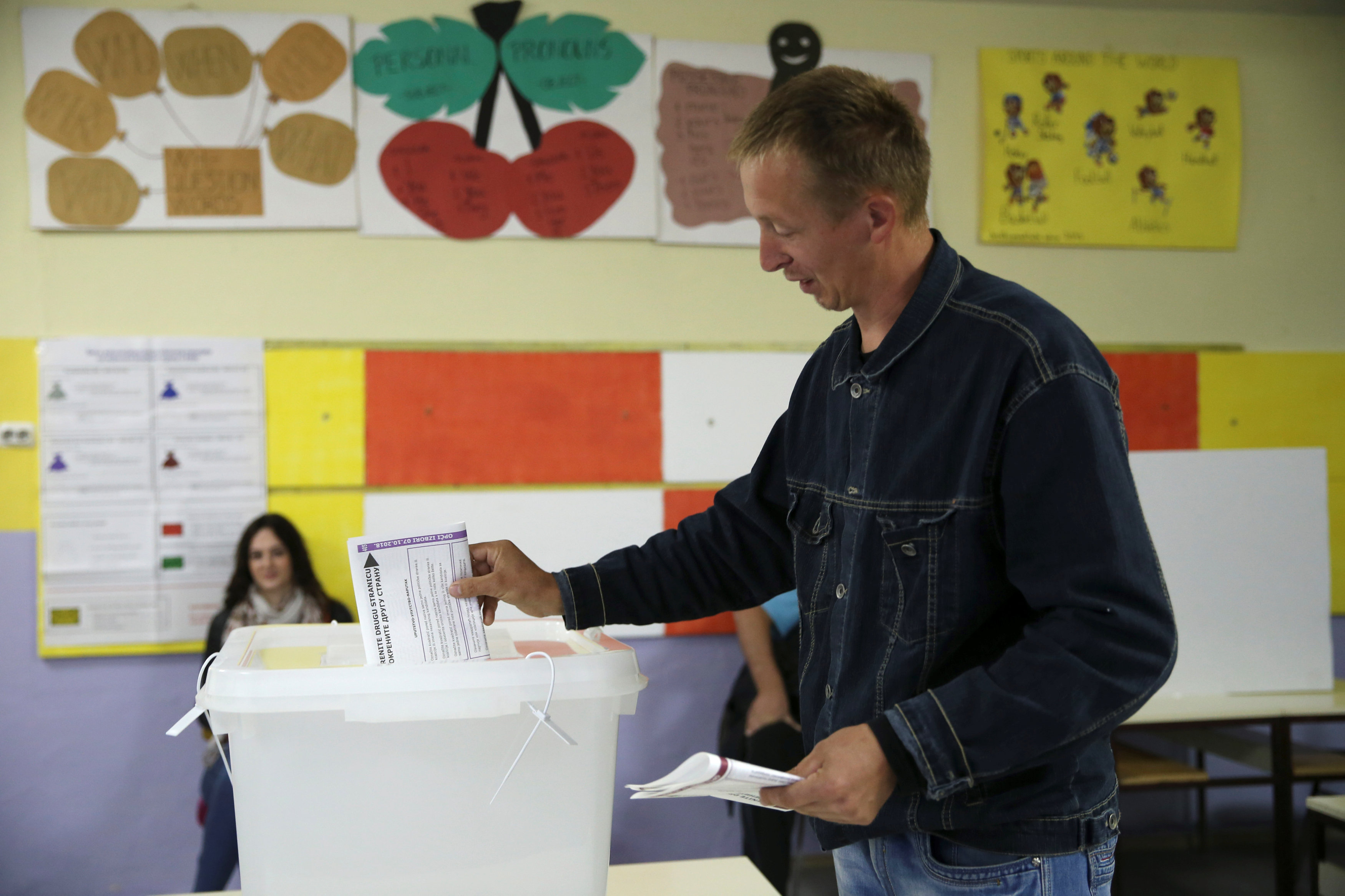 أحد المواطنين يضع ورقة الاقتراع بالصندوق بعدالتصويت
