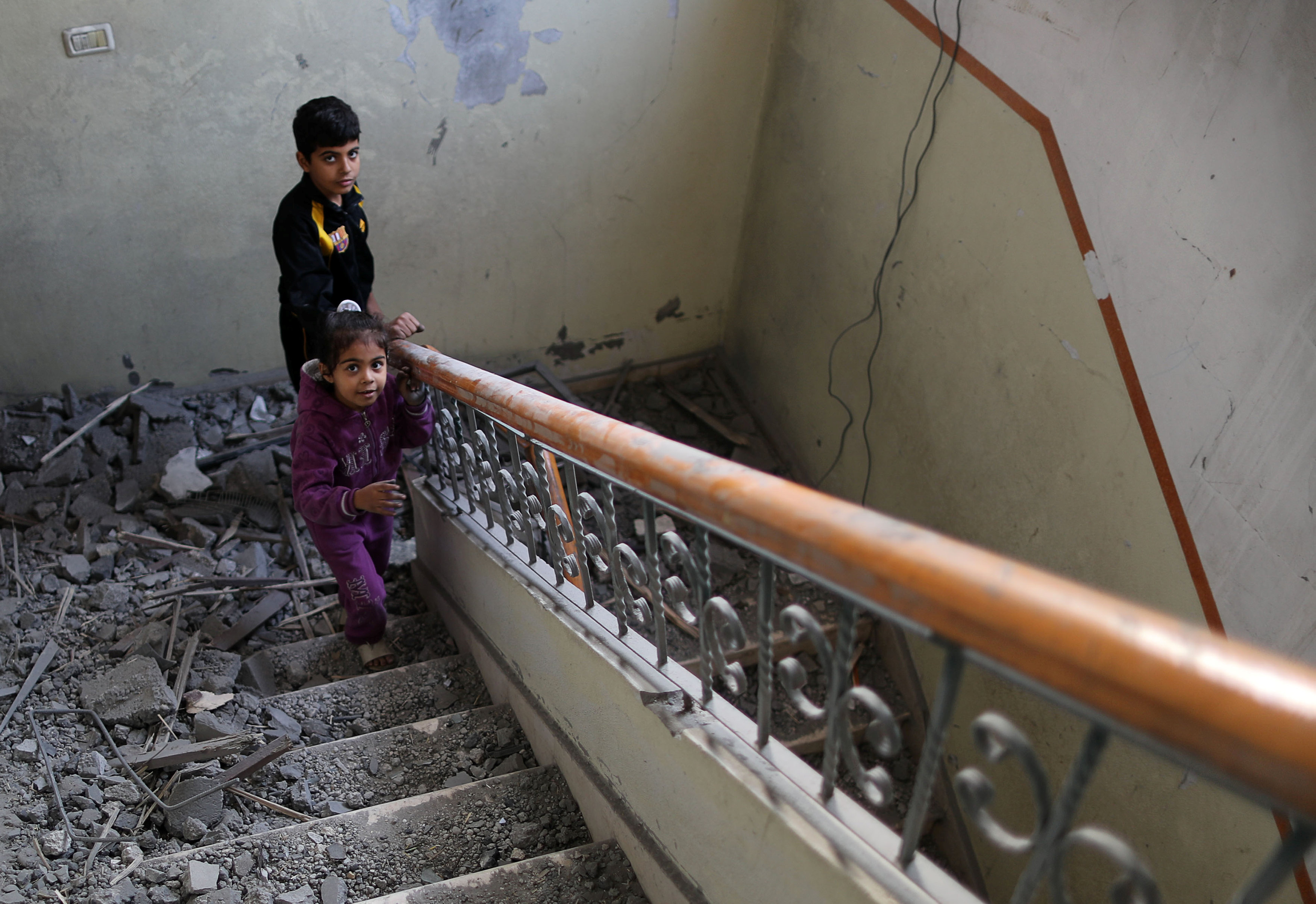 أطفال يصعدون على ركام من الحجارة من جراء القصف
