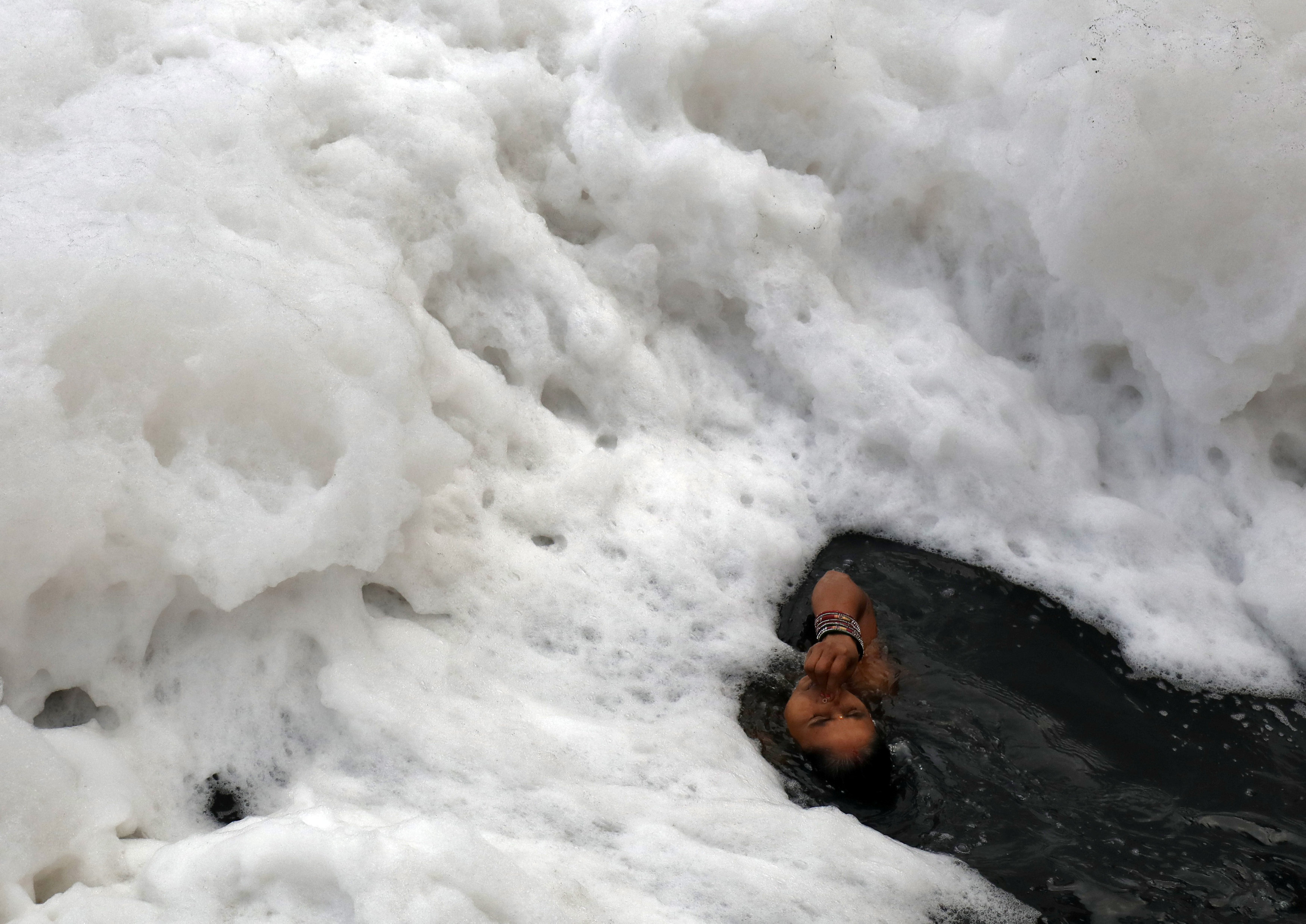 امرأة هندوسية فى مياه نهر يامانو خلال احتفالات عيد شاتا بوجا فى نيودلهى