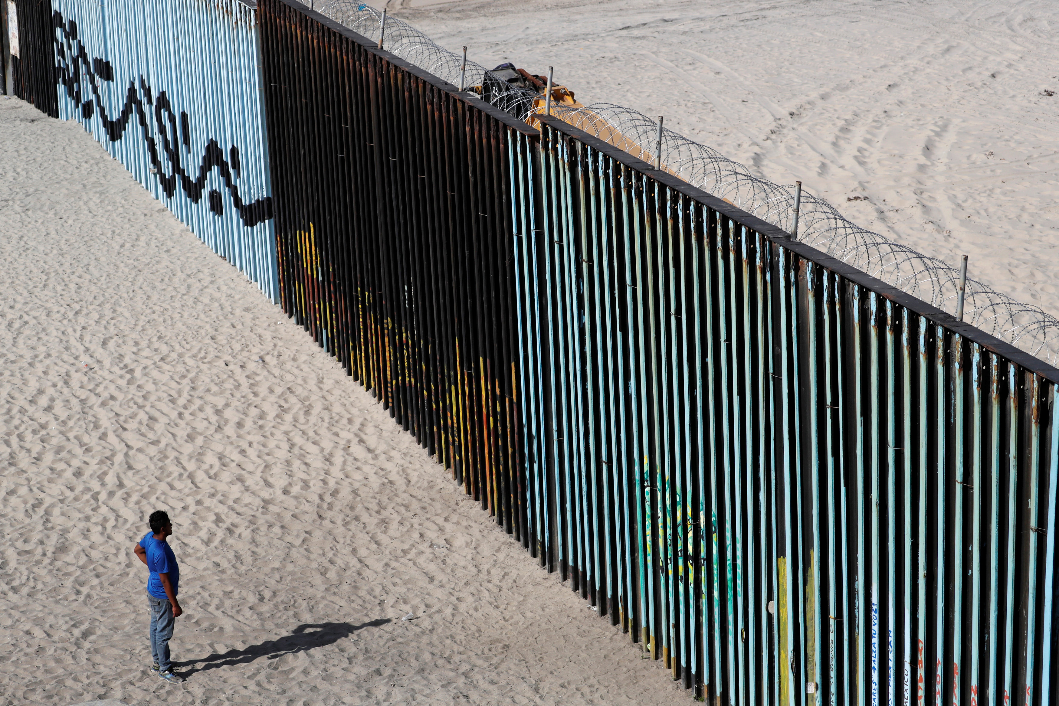مواطن من أمريكا الوسطى أمام جدار المكسيك