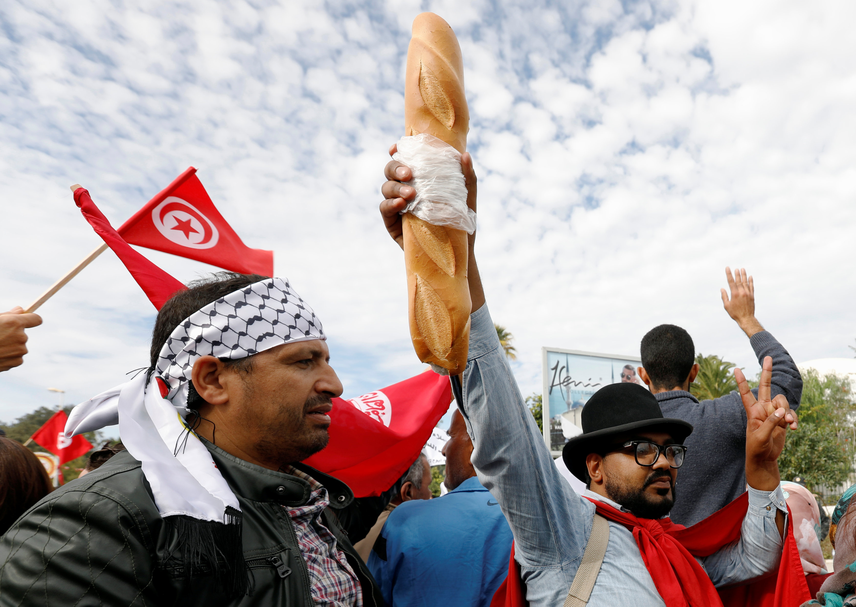مواطن يرفع رغيف خبز خلال مظاهرات اليوم فى تونس